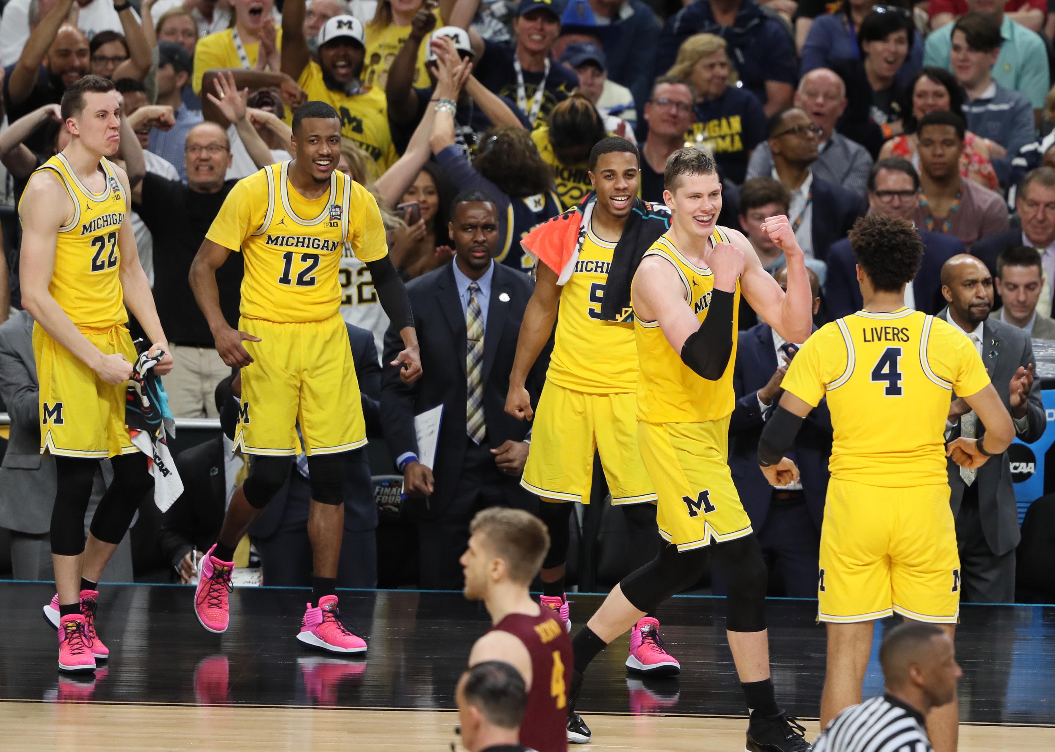 Michigan Wolverines forward Moritz Wagner (13) celebrates with teammates after scoring a basket in the second half against the Loyola Ramblers in a Final Four game at the Alamodome.