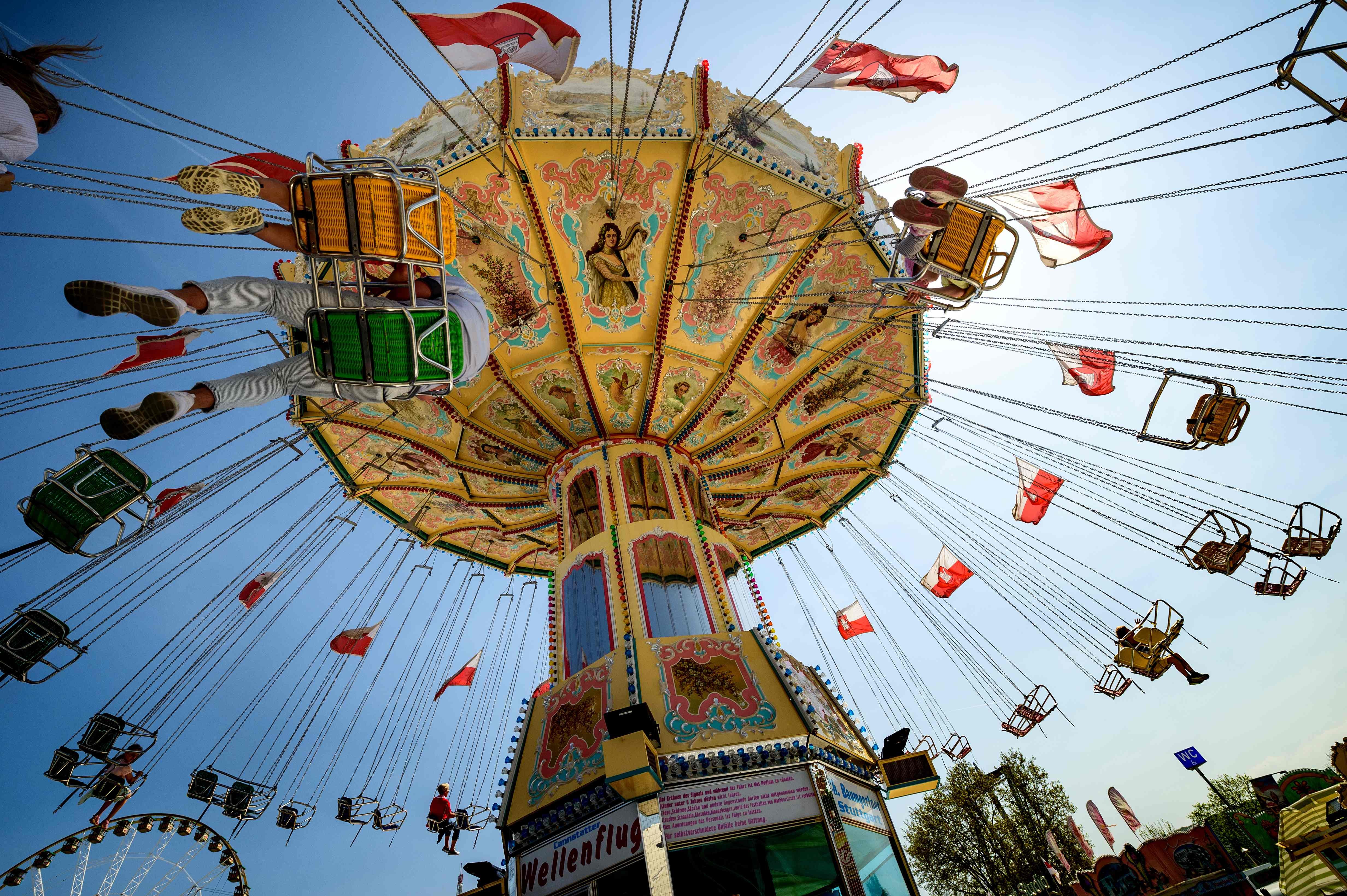 People ride on a chair swing at the fairgrounds in Stuttgart, Germany on April 21, 2018.