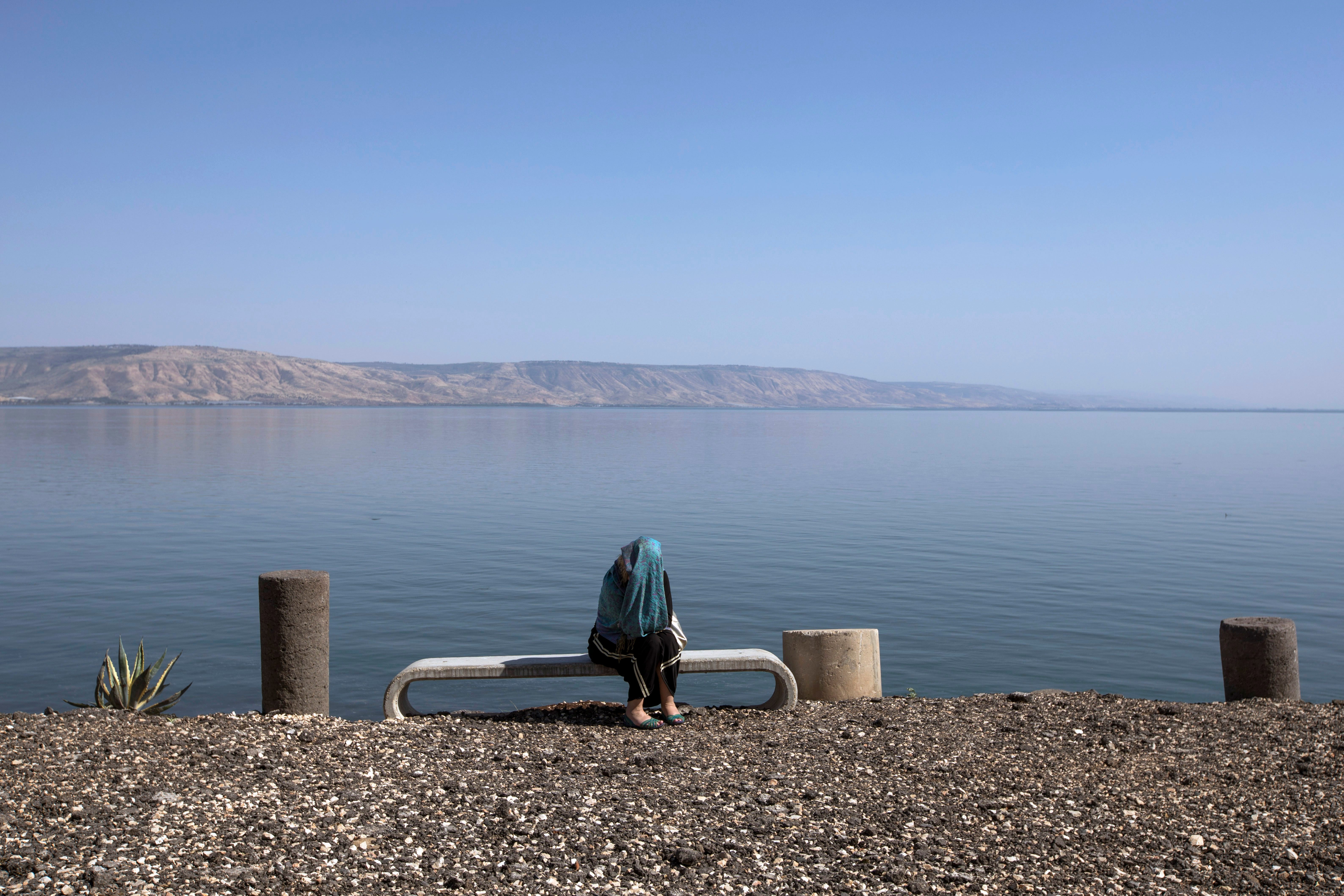 A traveler sits at the Sea of Galilee in Capernaum, the home town of Jesus, as part of the Jesus Trail in Capernaum, northern Israel.