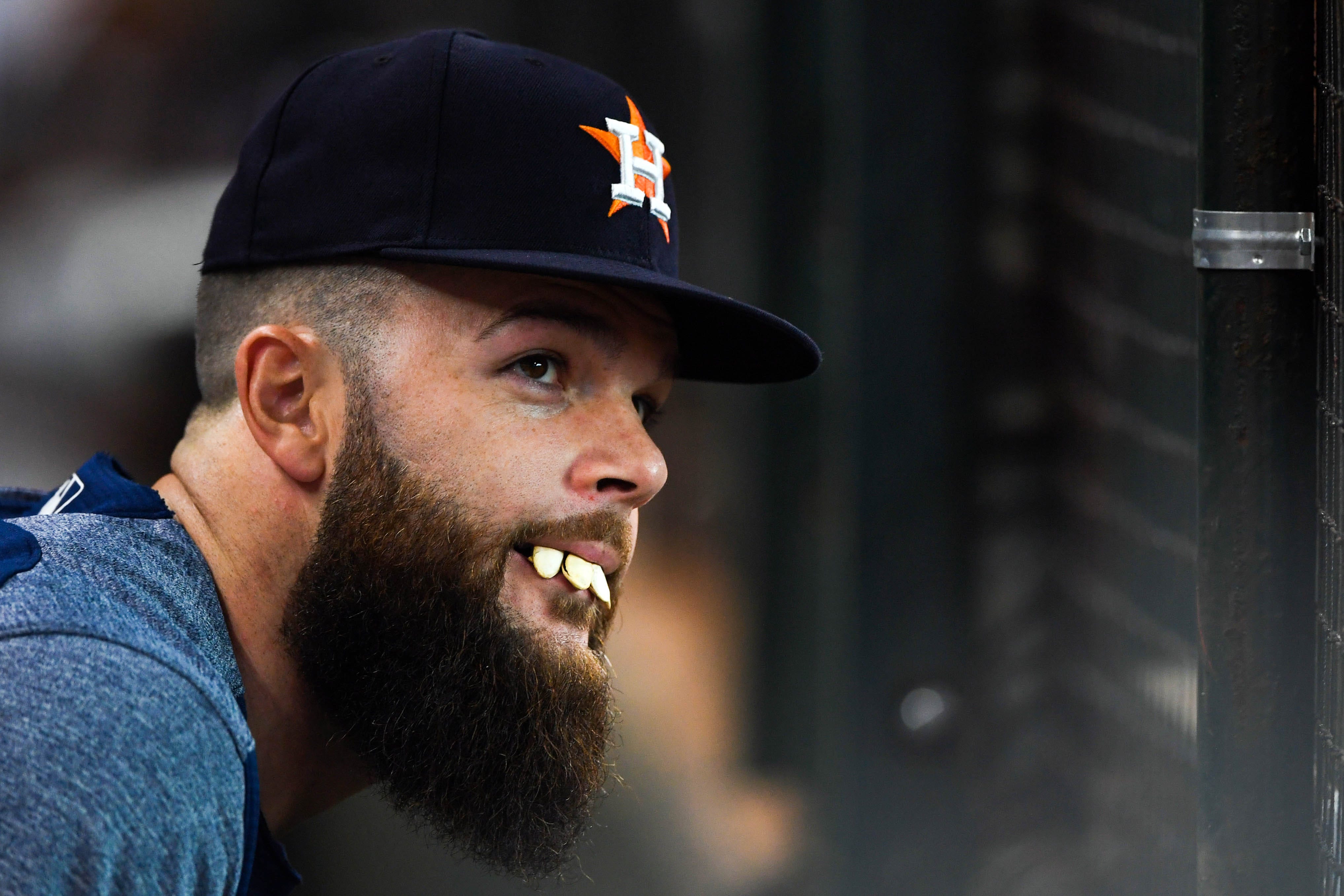 Houston Astros starting pitcher Dallas Keuchel makes teeth out of pumpkin seeds in the dugout during the third inning against the New York Yankees at Minute Maid Park in Houston.