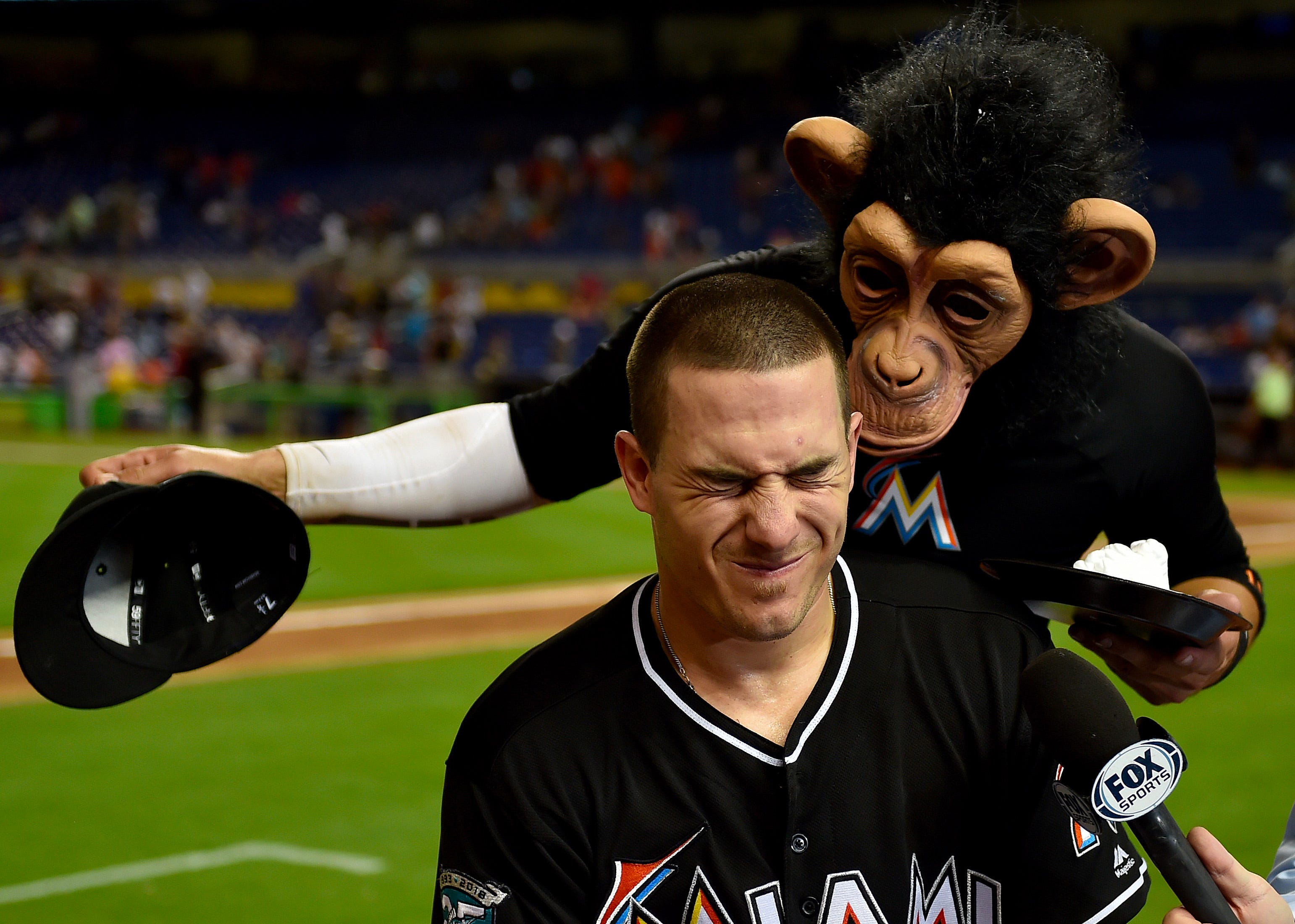 Miami Marlins J.T. Realmuto receives a shaving cream pie from Miami Marlins shortstop Miguel Rojas after their win over the Atlanta Braves at Marlins Park.