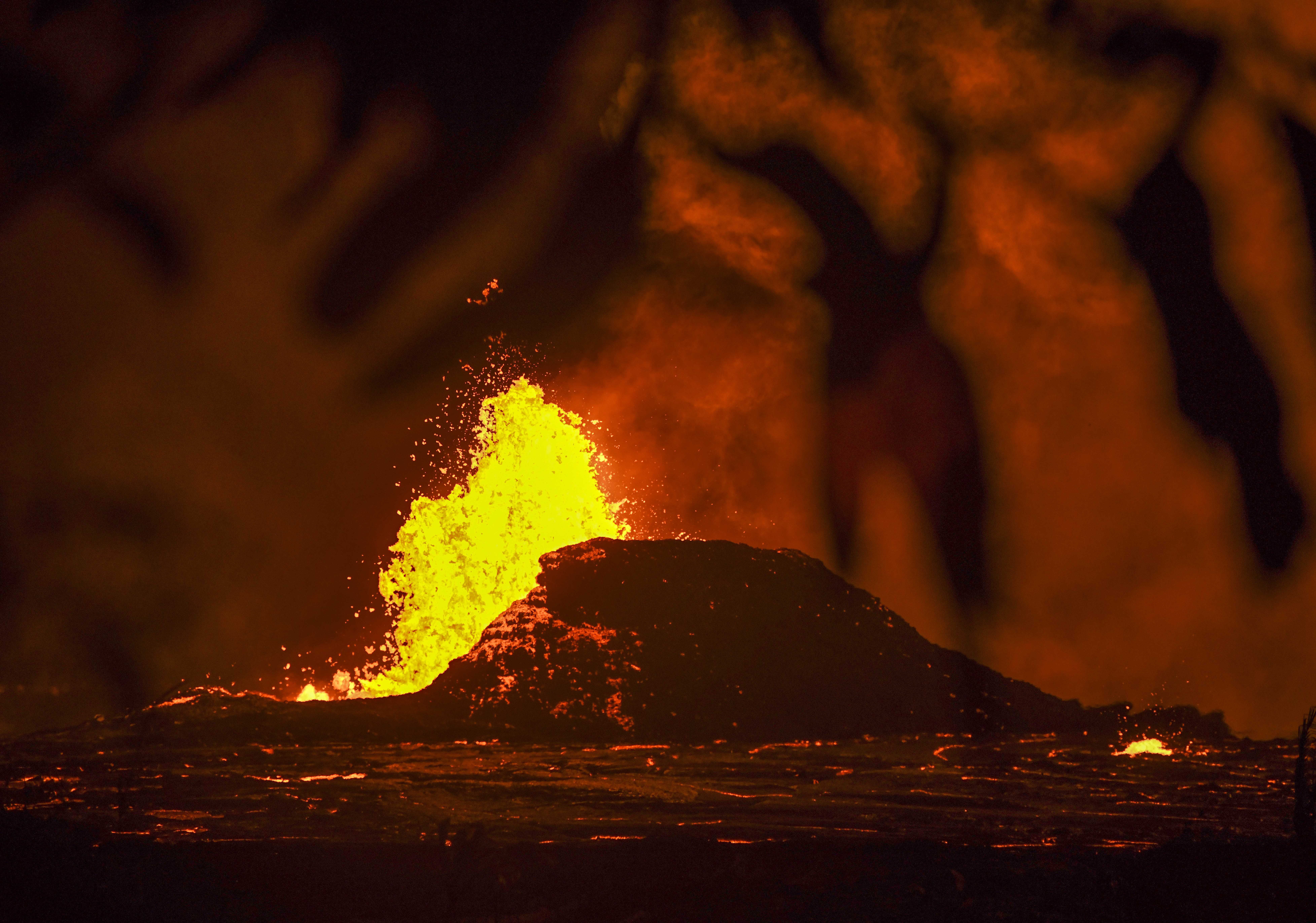 Lava from the Kilauea Volcano pours out of fissures in the earth creating an eerie nighttime scene on May 23, 2018 in Pahoa, Hawaii.  Kilauea is one of the most active volcanoes in the world and one of five on the Big Island of Hawaii. It erupted May 