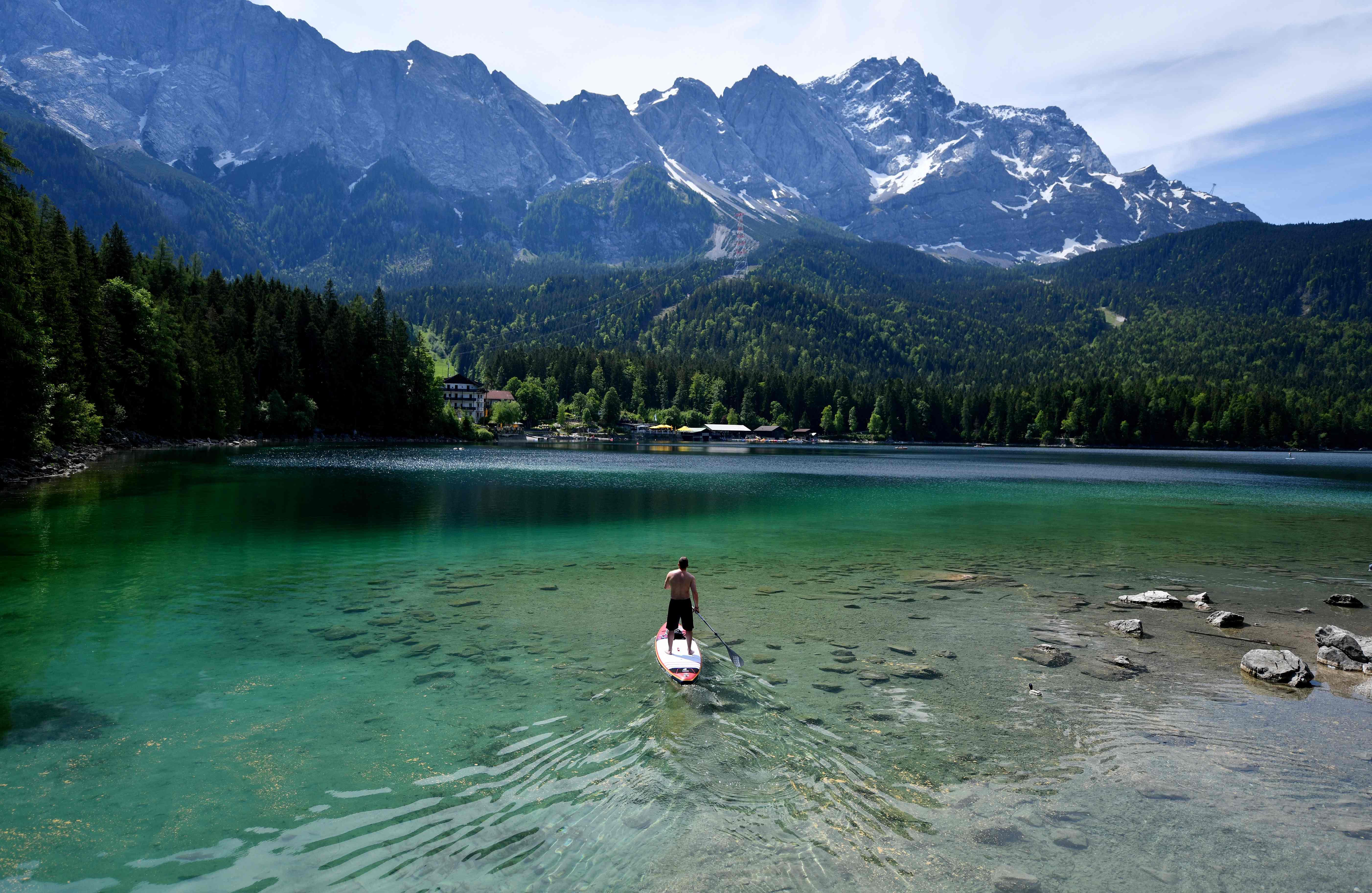 A man uses a paddle board on the Eibsee lake on May 25, 2018 in Grainau, Germany.