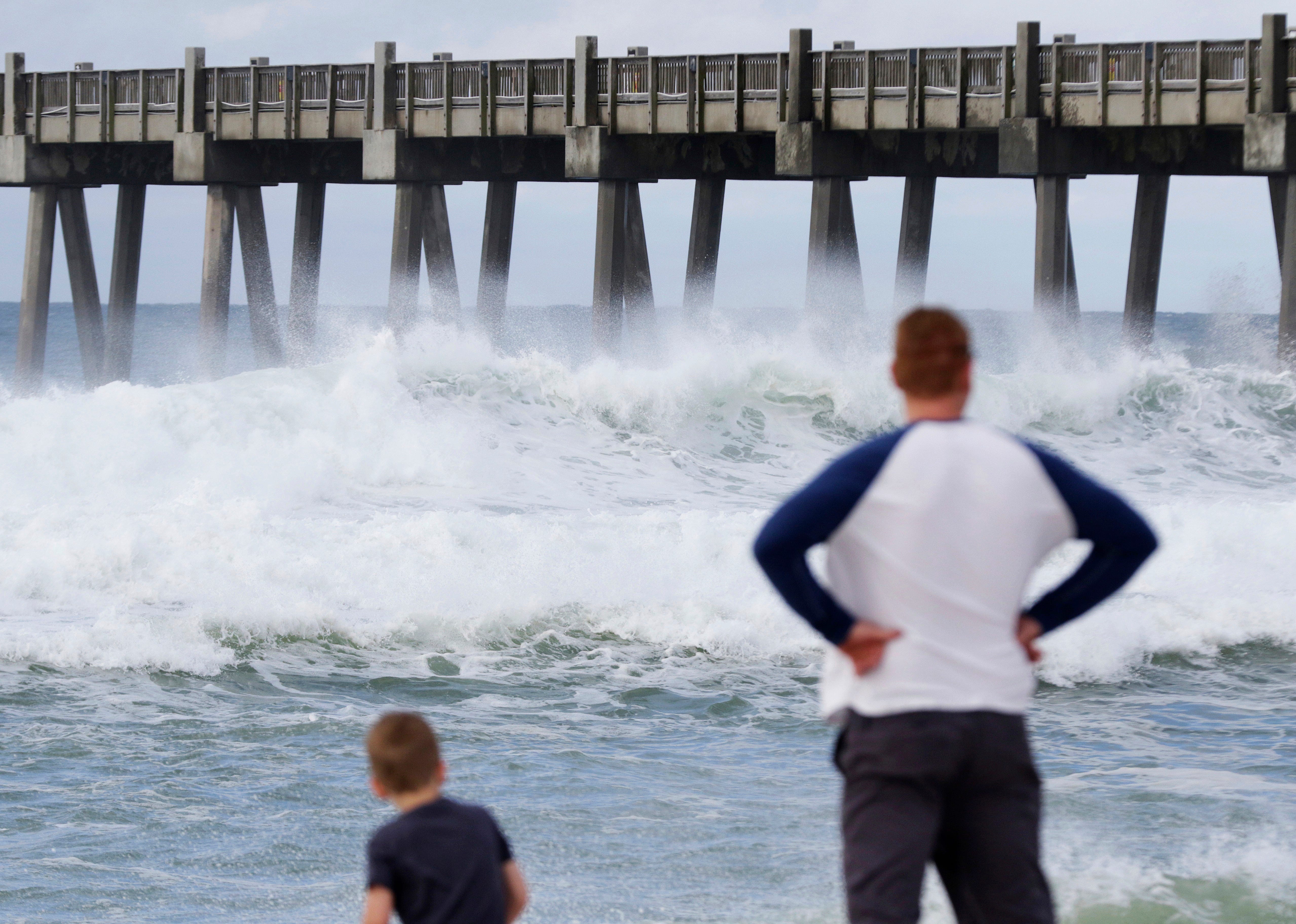 Harrison Westwood, 4, left, and his father Ben watch waves crash near the beach as a subtropical storm approaches on May 28, 2018, in Pensacola, Fla. The storm gained the early jump on the 2018 hurricane season as it headed toward anticipated landfal