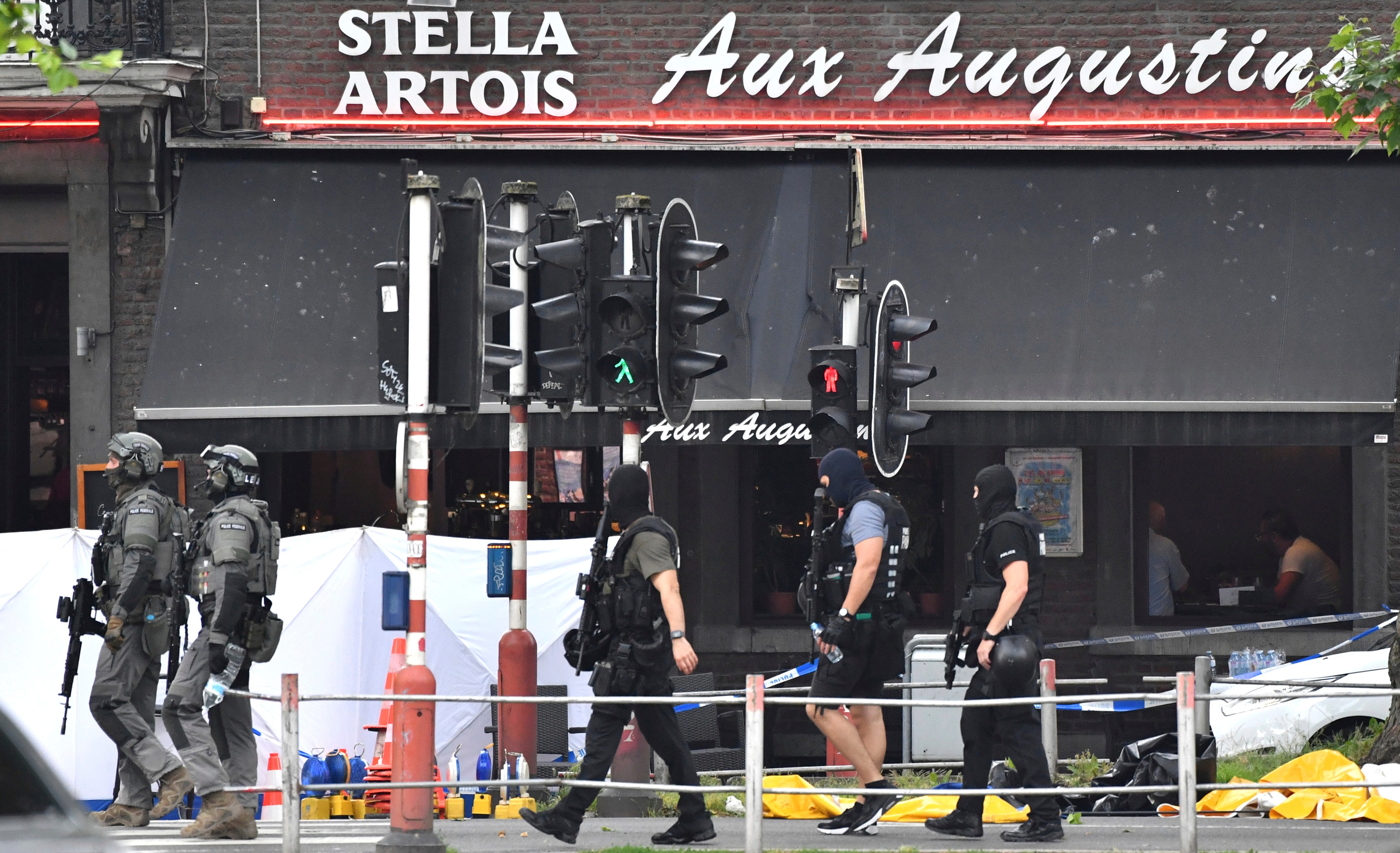 Belgian Special Police walk by the scene of a fatal attack in Liege, Belgium, Tuesday, May 29, 2018. An attacker killed three people, including two police officers, in the Belgian city of Liege on Tuesday, a city official said. Police later killed th