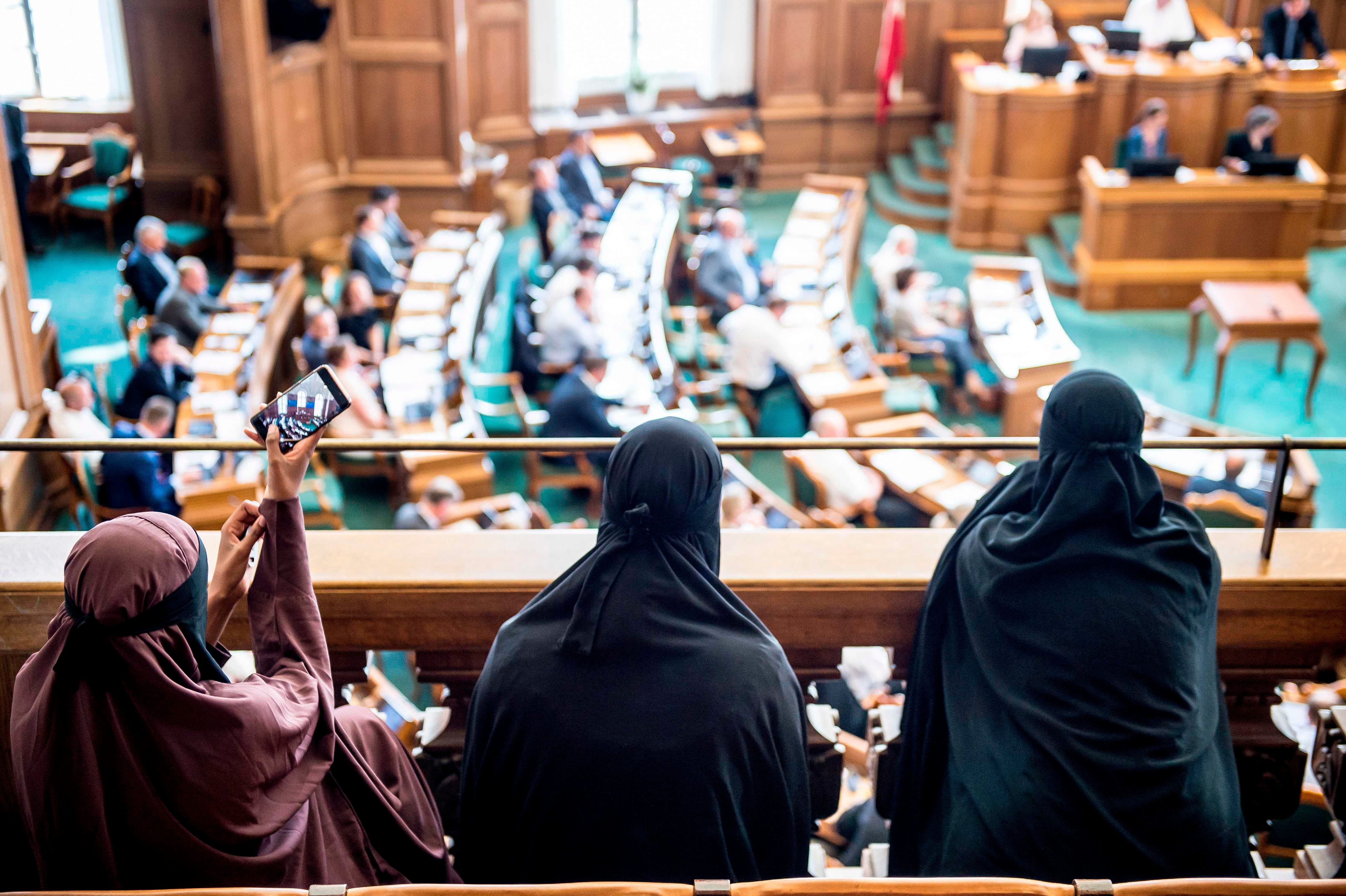 Women wearing niqab sit in the audience at the Danish Parliament in Copenhagen, Denmark, on May 31, 2018.   The Danish parliament on May 31,2018, passed a law banning the Islamic full-face veil in public spaces, becoming the latest European country to