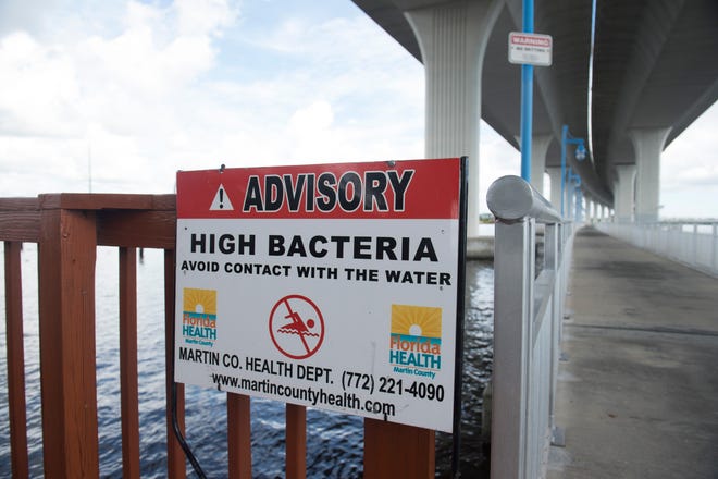 A sign posted by the Martin County Health Department warned people of water filled with high bacteria, which could potentially include toxic blue-green algae, Thursday, June 14, 2018 under the Roosevelt Bridge in downtown Stuart.