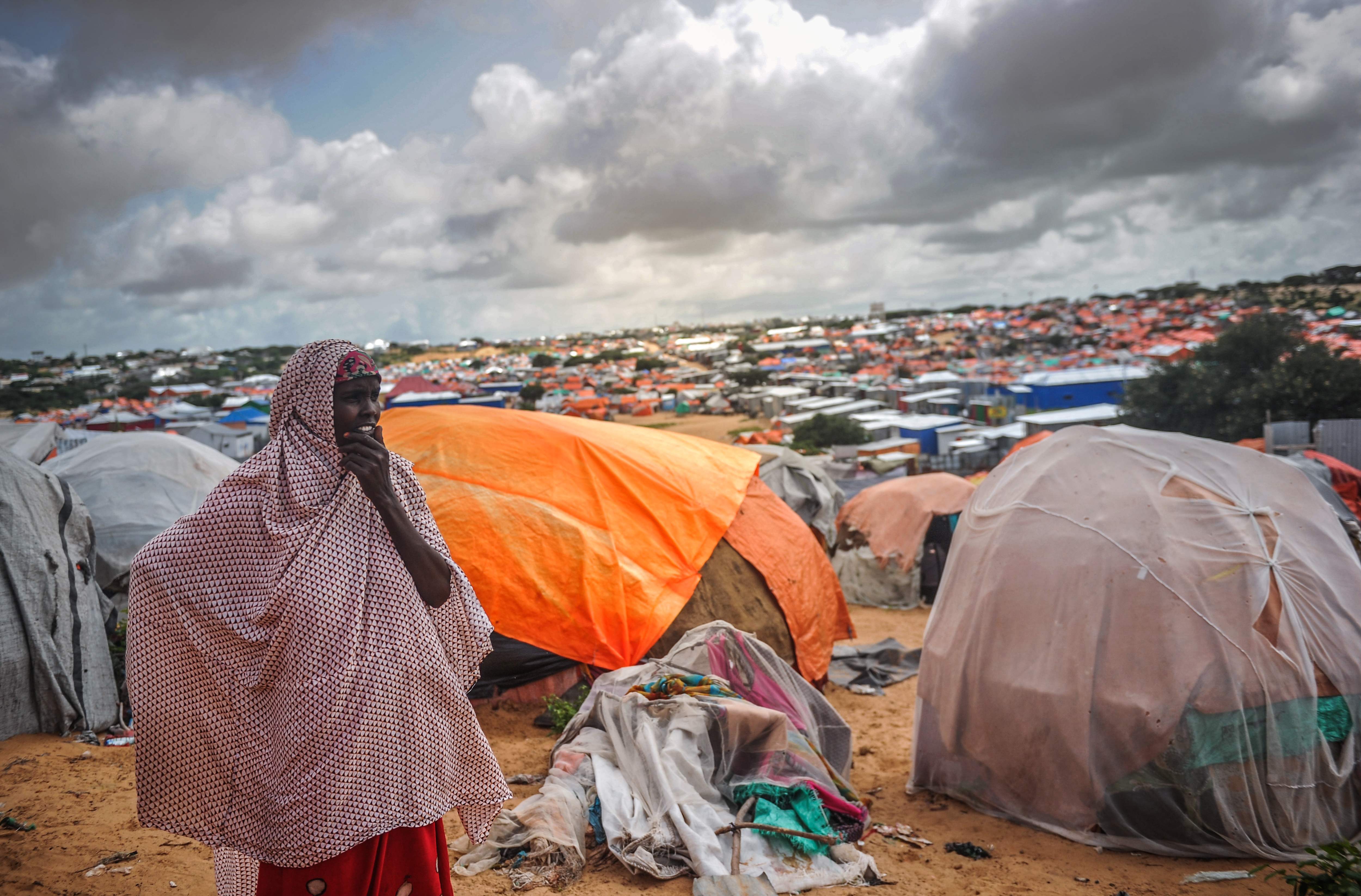 A Somali woman stands next to her makeshift tent at Tawakal IDP camp in Mogadishu, Somalia, on June 19, 2018.