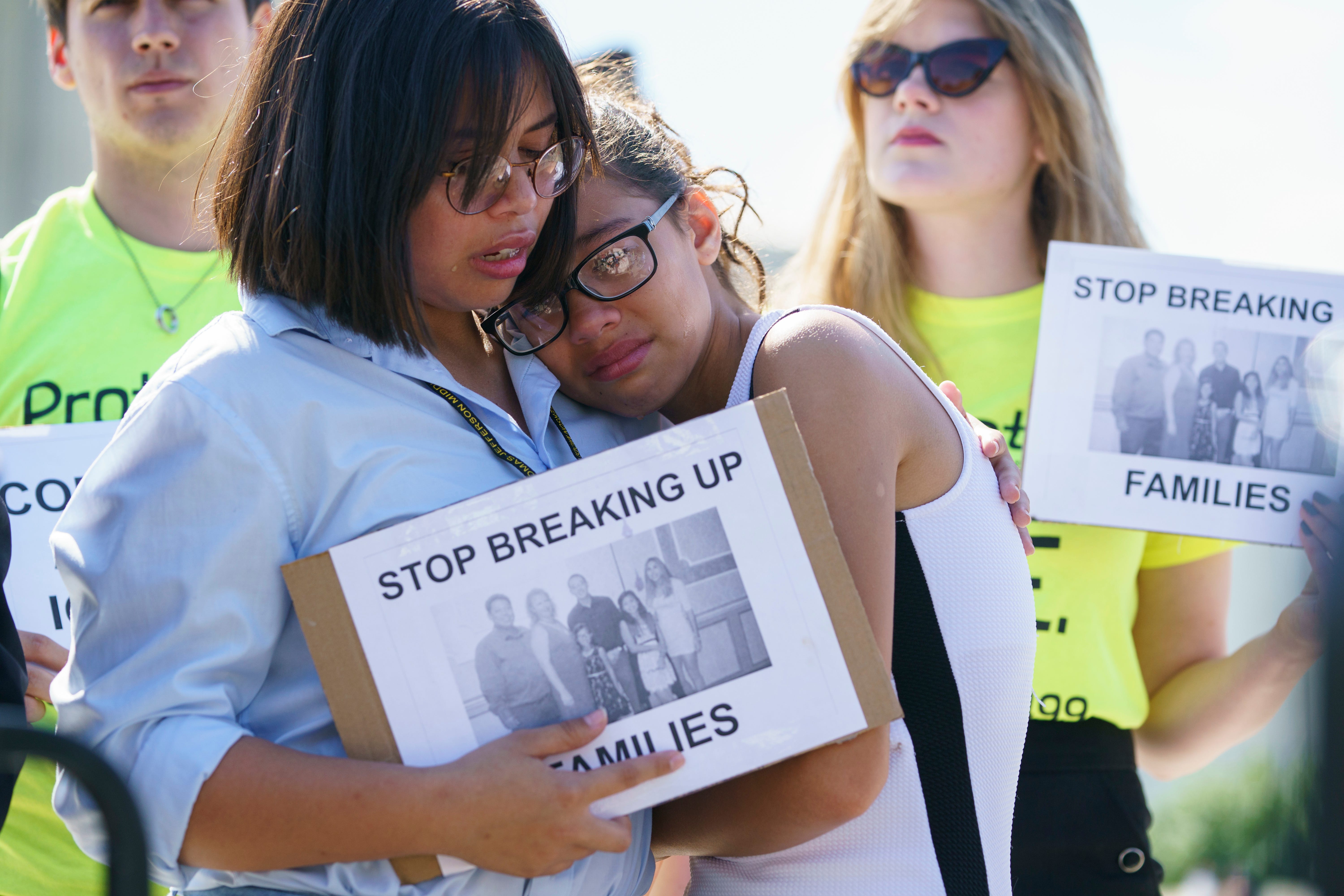 Nicole Edralin, 15, left, comforts her sister Michelle Edralin, 12, both of Highland Park, N.J., as they protest outside the Supreme Court Building on Capitol Hill in in Washington,  June 26, 2018. Their father Cloyd is currently being detained by IC