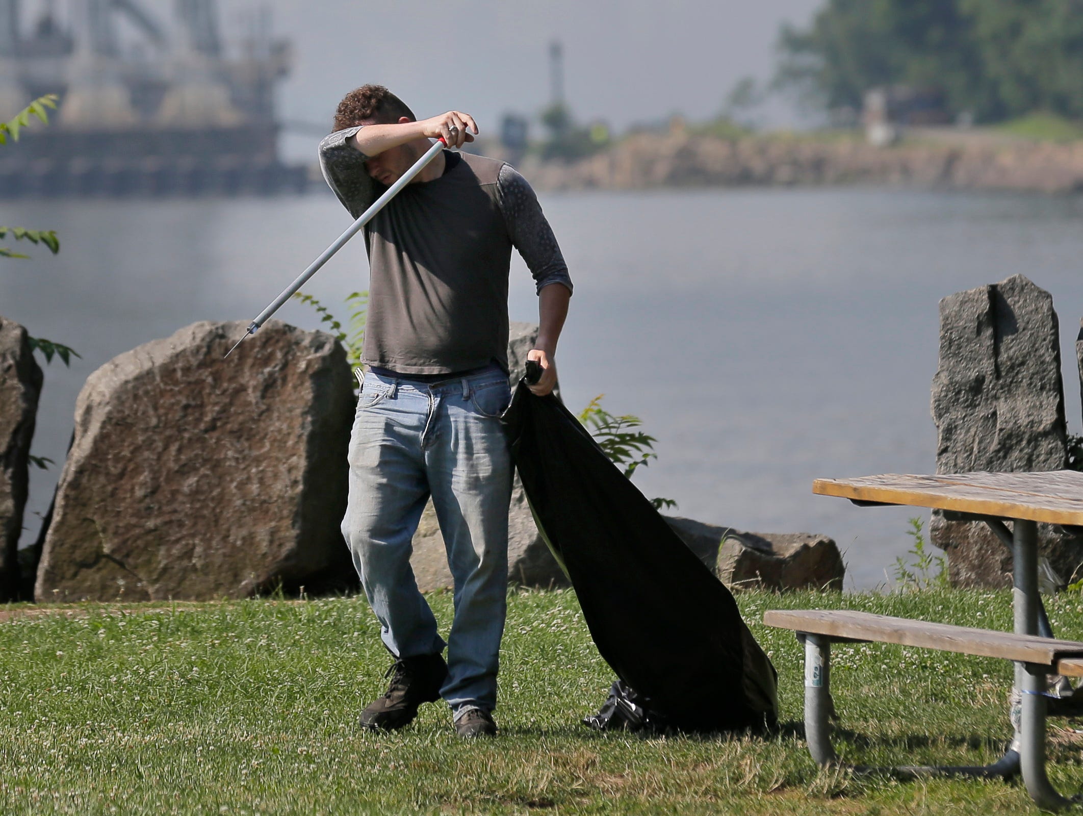 Robert Gidney, left, wipes away sweat while working in Palisades Interstate Park in Ft. Lee, N.J., July 2, 2018. The National Weather Service has most of New Jersey state under an excessive heat warning or heat advisory, with heat indices predicted t