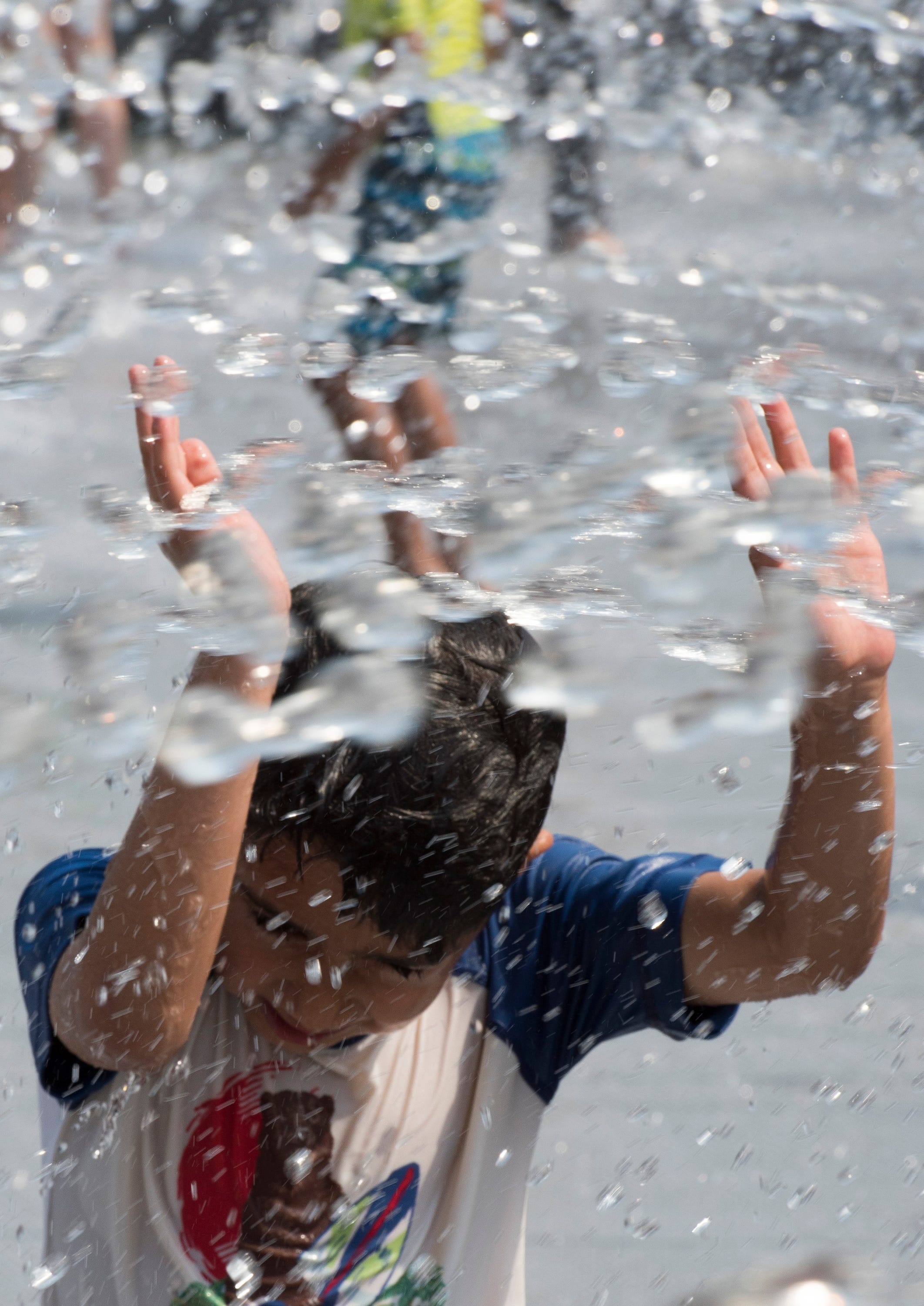 Children cool off in the water spray park at Georgetown Waterfront Park in Washington D.C. as temperatures continue to soar in the 90s to near 100 degrees on July 3, 2018.