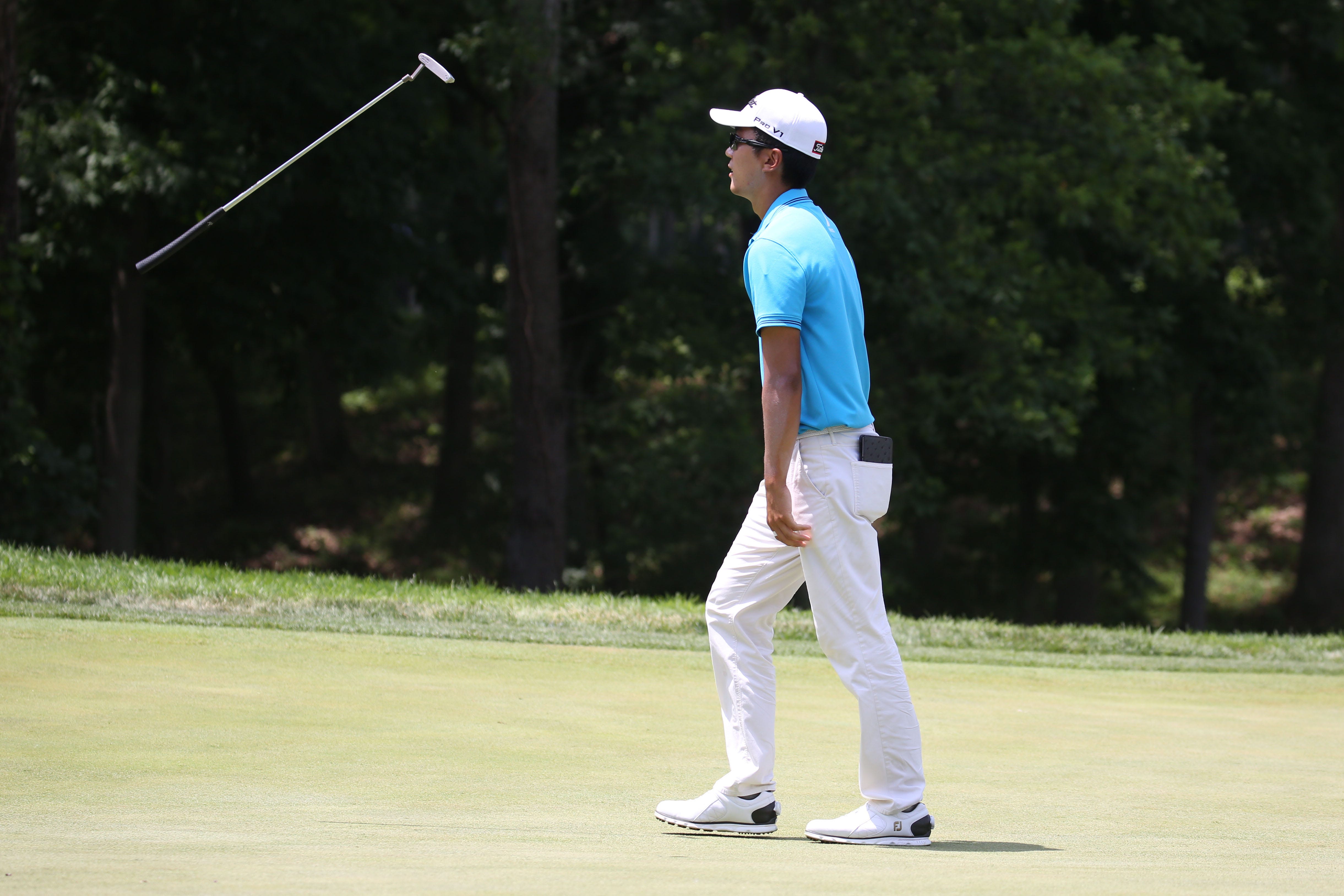 PGA golfer Michael Kim reacts to missing a birdie putt on the 9th hole by tossing his putter in the air during the first round of the John Deere Classic golf tournament at TPC Deere Run.