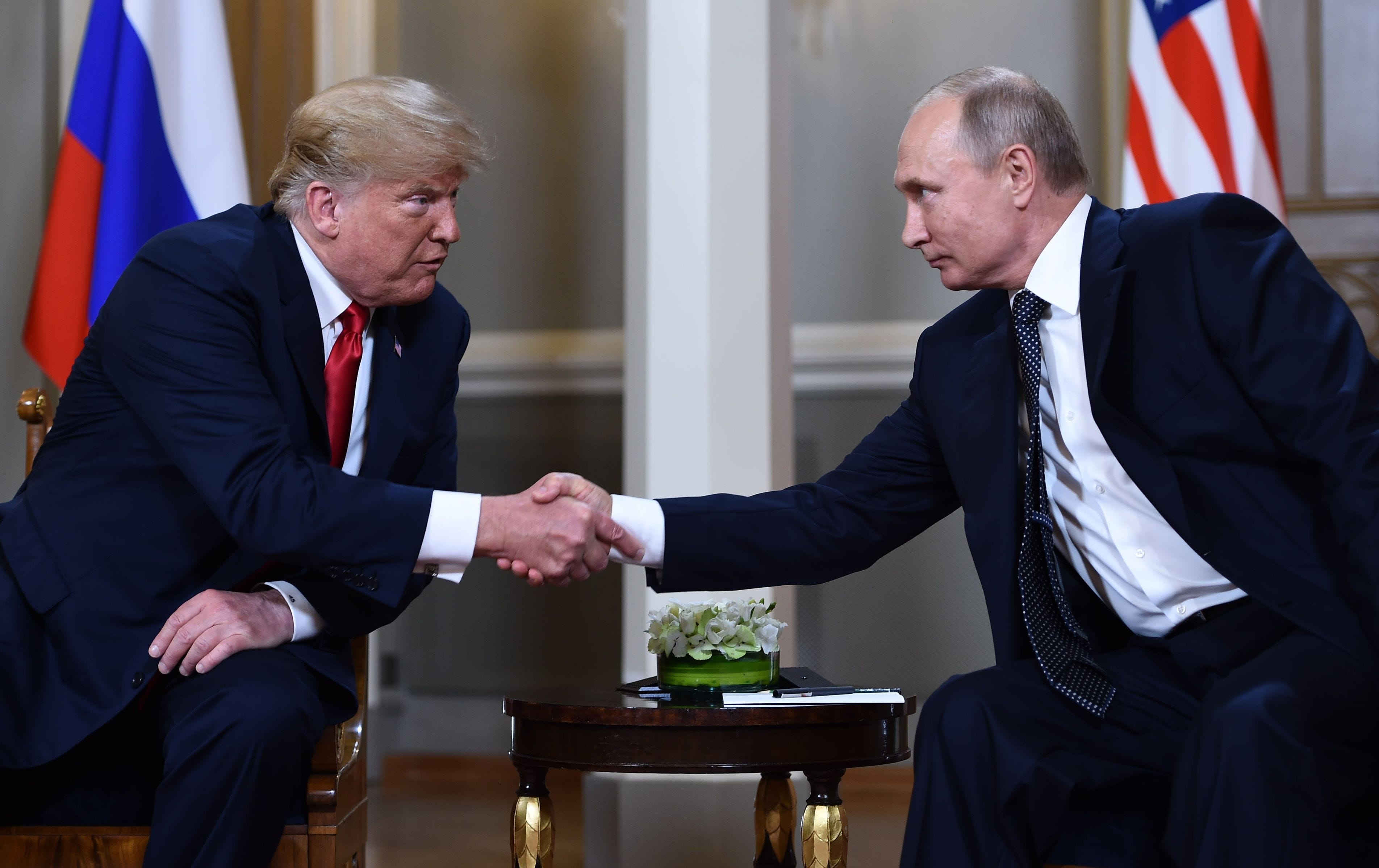 Russian President Vladimir Putin (R) and President Trump shake hands before a meeting in Helsinki, on July 16, 2018.