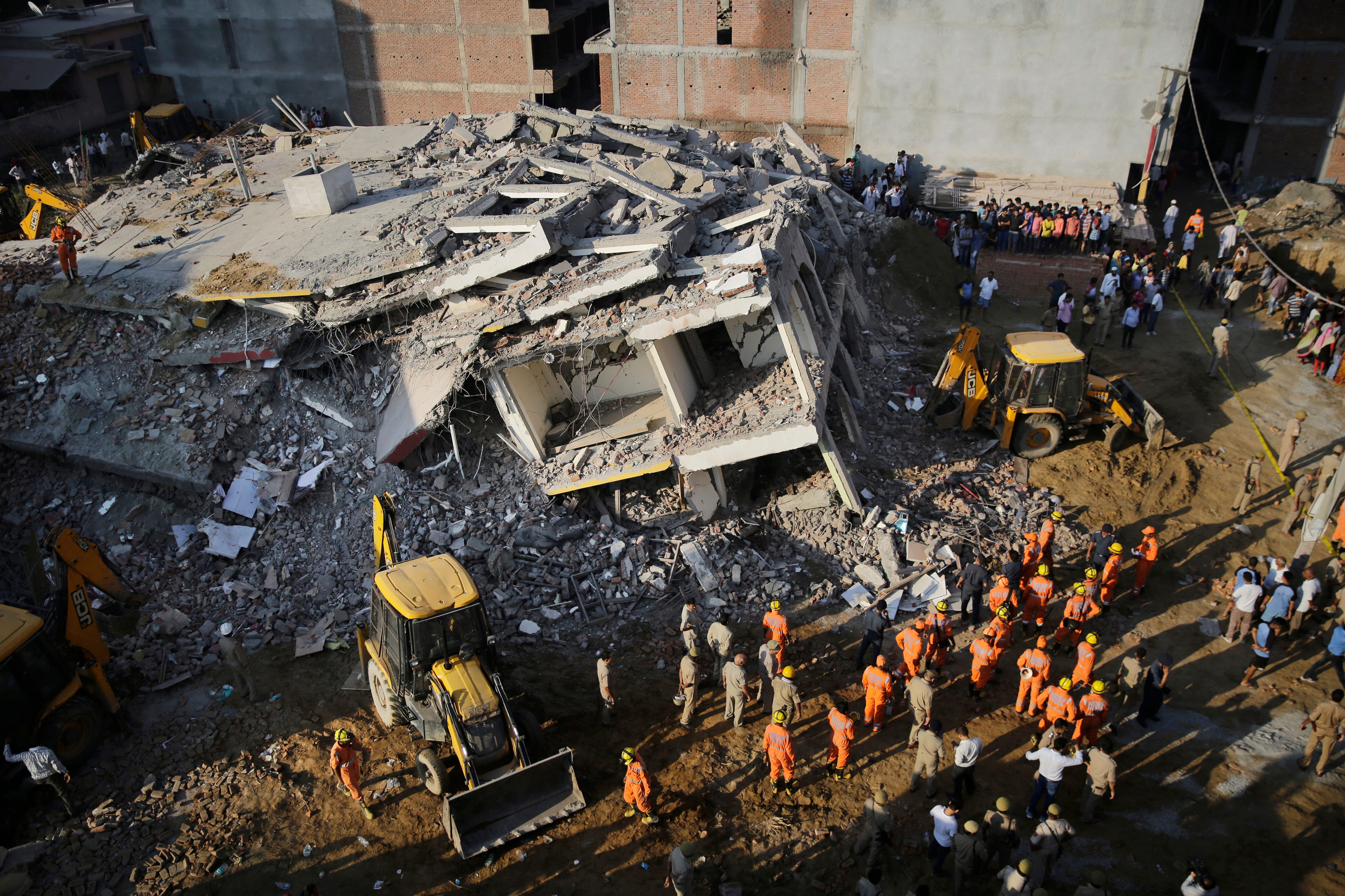 Rescuers work at the site of a building collapsed in Shahberi village, east of New Delhi, India, July 18, 2018. The six-story building under construction collapsed onto an adjacent building.