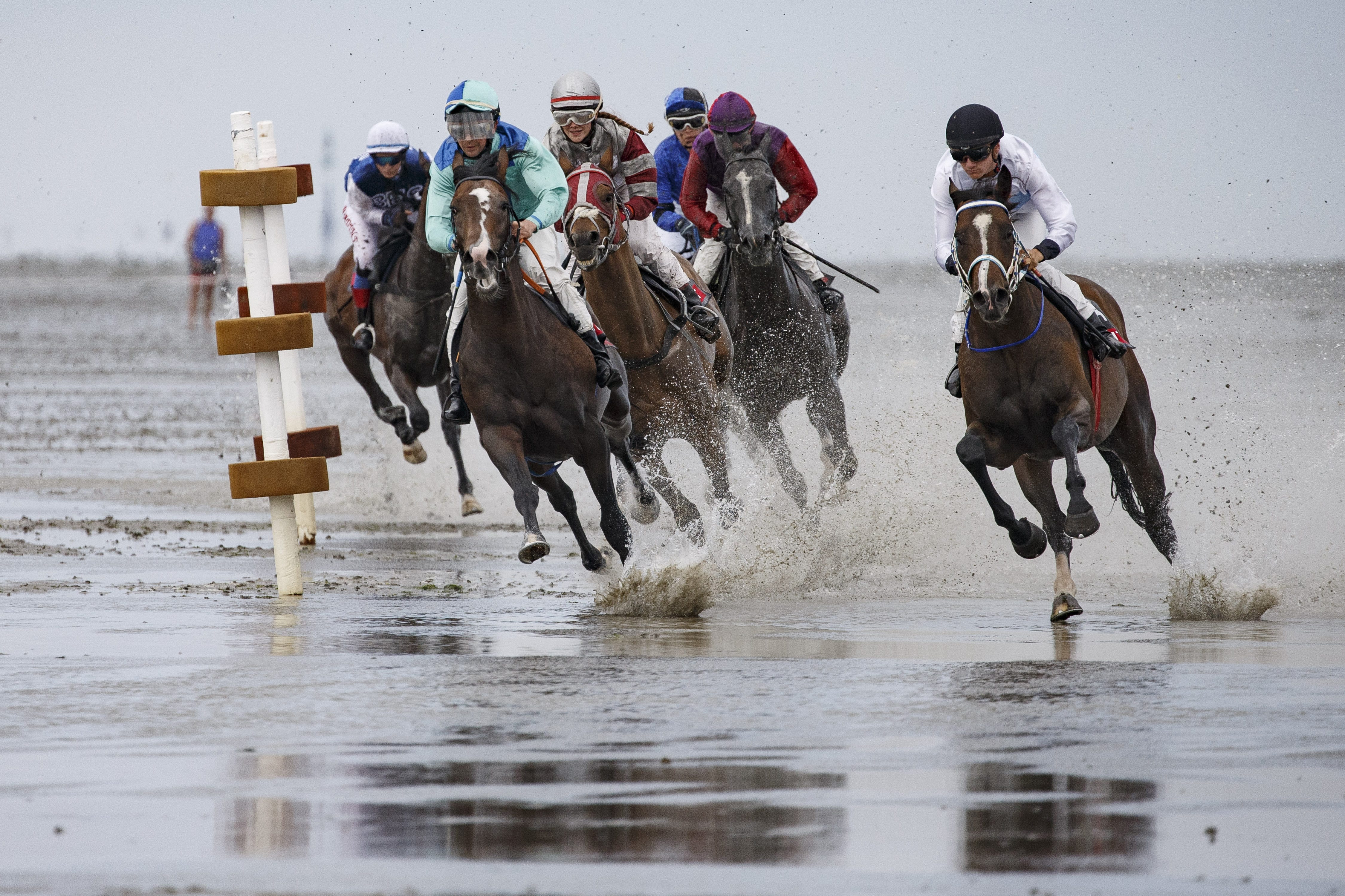 Horses and riders compete in the annual horse buggy races on the mudflats at Duhnen in Cuxhaven, Germany. The races, which in German are known as the Duhner Wattrennen, take place at low tide throughout the day and have been an annual tradition since