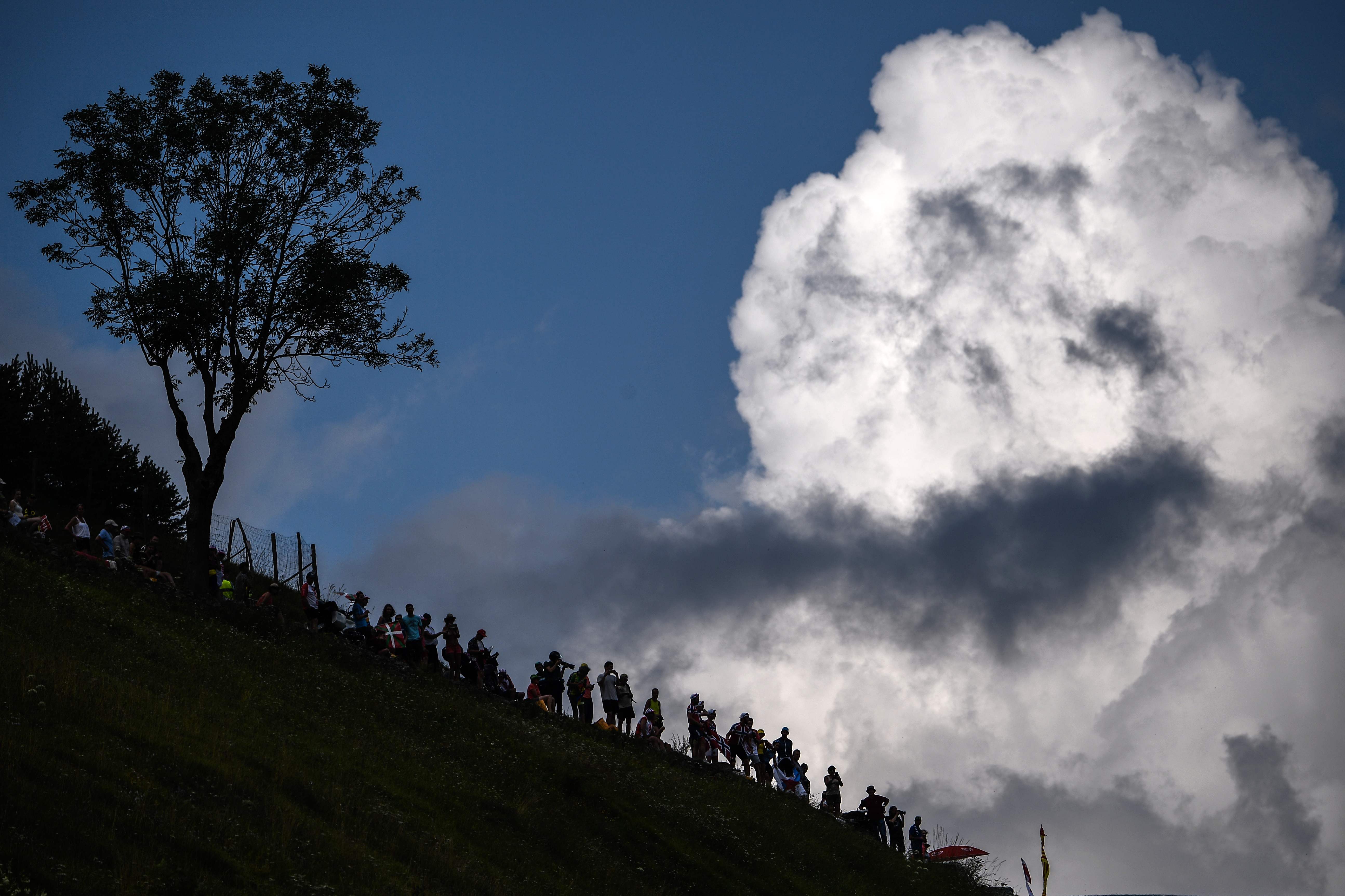 Spectators gather on a slope of the first pass during the 17th stage of the 105th edition of the Tour de France cycling race between Bagneres-de-Luchon and Saint-Lary-Soulan Col du Portet, France, on July 25, 2018.