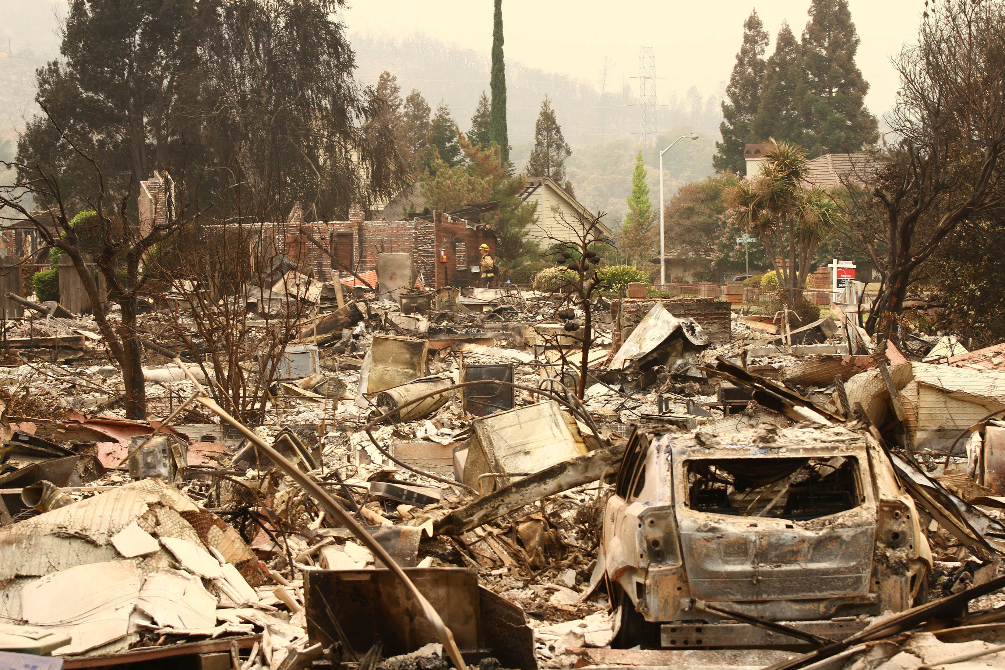 A firefighter walks through a residential area destroyed by the Carr wildfire in Salt Creek Heights, Calif. on July 29, 2018.  Firefighters battling intense heat and strong winds struggled Monday to gain control of a deadly Northern California wildfir