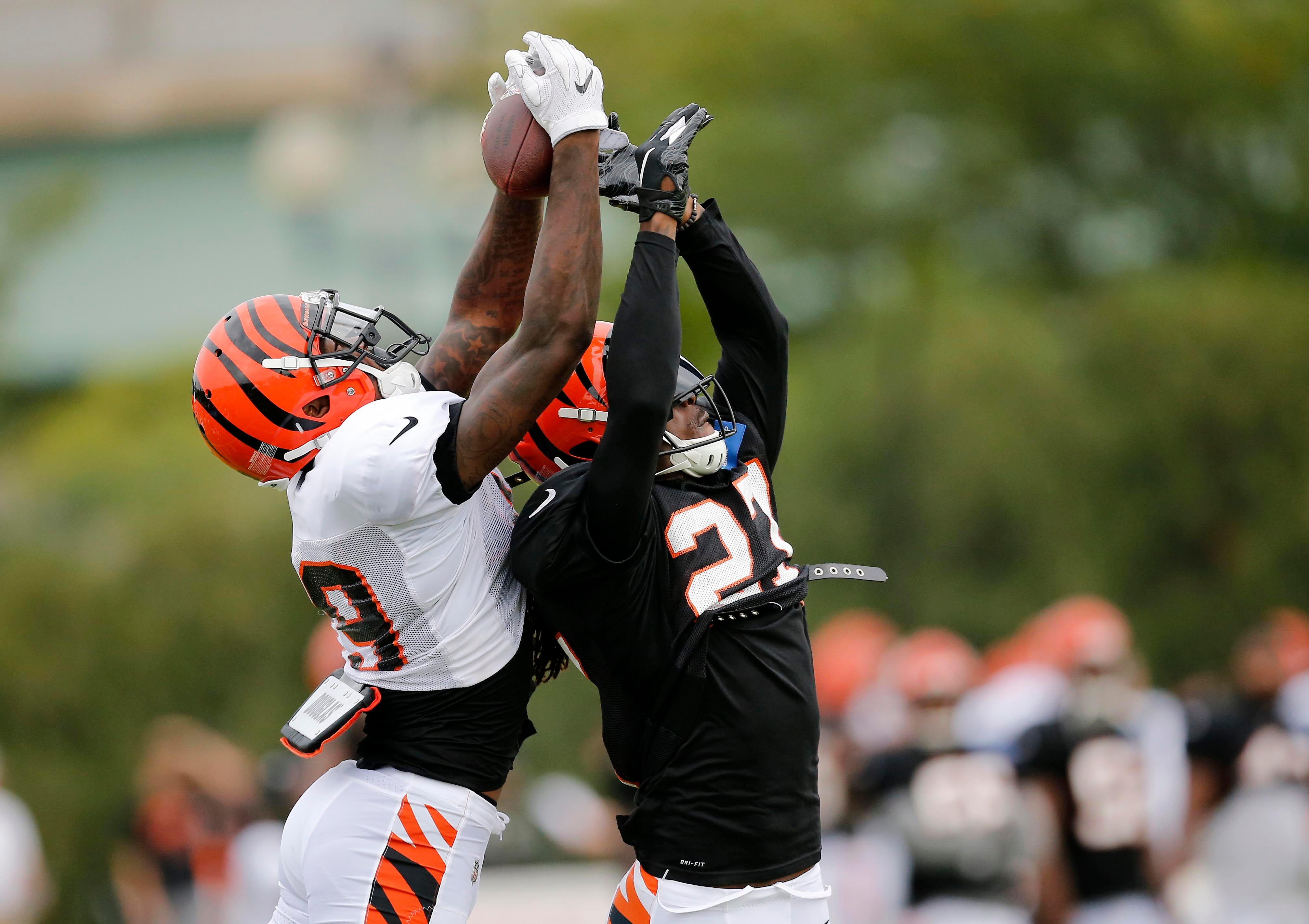 Cincinnati Bengals wide receiver Auden Tate, left, catches a pass over defensive back Dre Kirkpatrick during a camp practice session at the Paul Brown Stadium practice facility in Cincinnati.