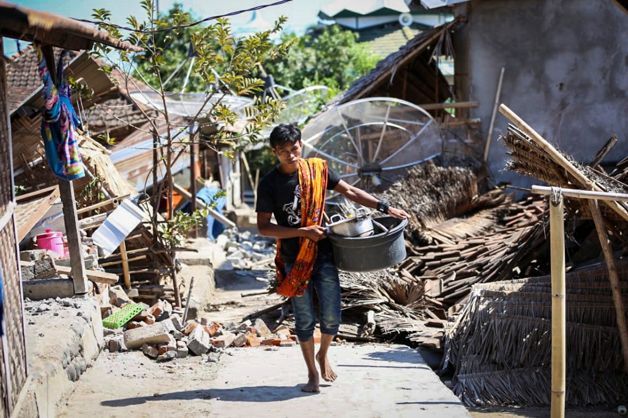 An Indonesian man collects his belongings from his collapsed house after an earthquake struck in North Lombok, West Nusa Tenggara, Indonesia, on Aug. 6, 2018. According to media reports, a 7.0 magnitude quake hit Indonesia's island of Lombok on Aug. 