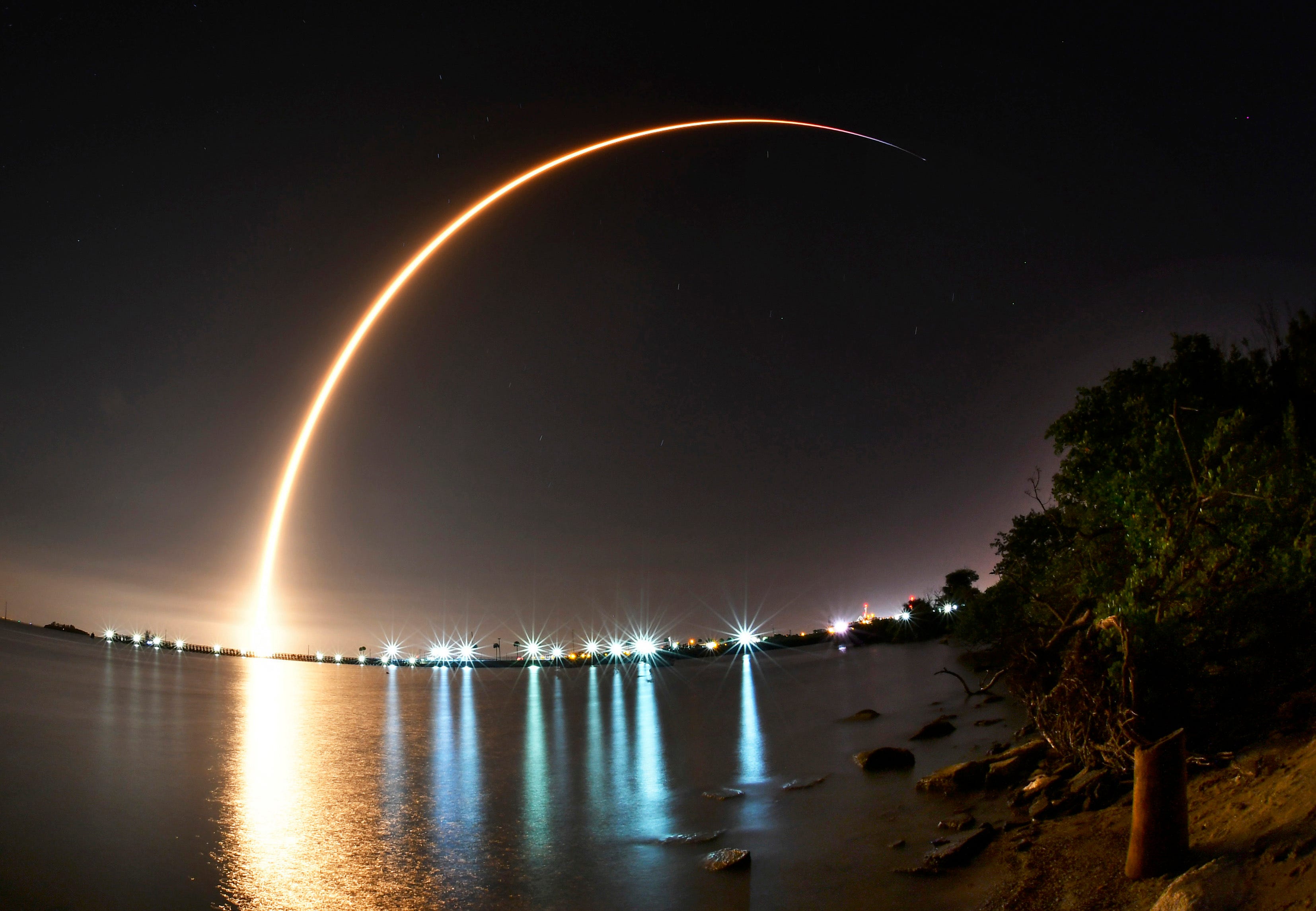 A SpaceX Falcon 9 rocket carrying a Putih/Telkom-4 communications satellite lifts off from Launch Complex 40 at Cape Canaveral Air Force Station, Fla. The images is a 147-second time exposure of the launch with the lights of the Canaveral Lock in the