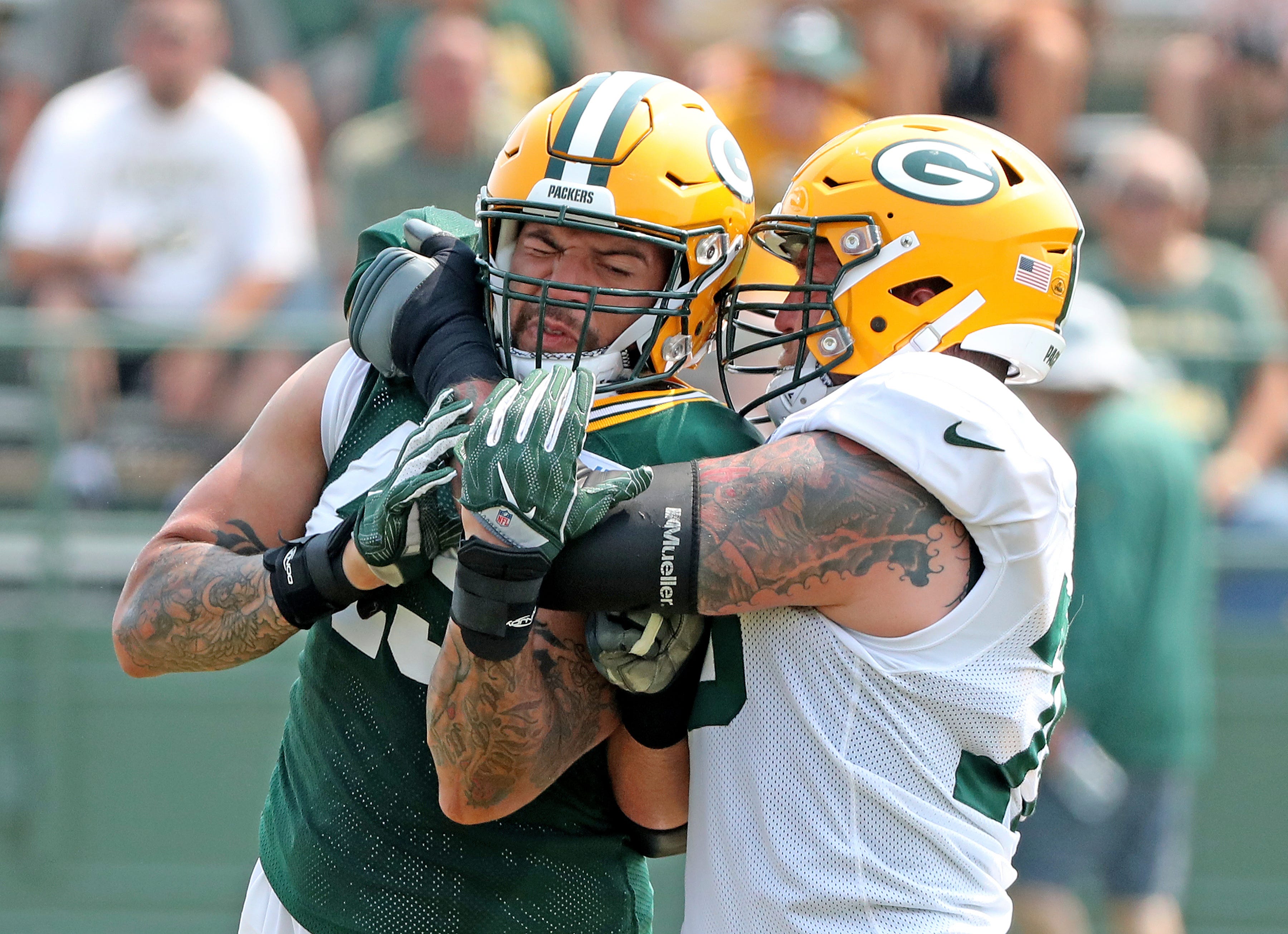 Green Bay Packers offensive tackle Jason Spriggs, right, grapples with linebacker James Hearns during NFL football training camp at Ray Nitschke Field in Ashwaubenon, Wis.