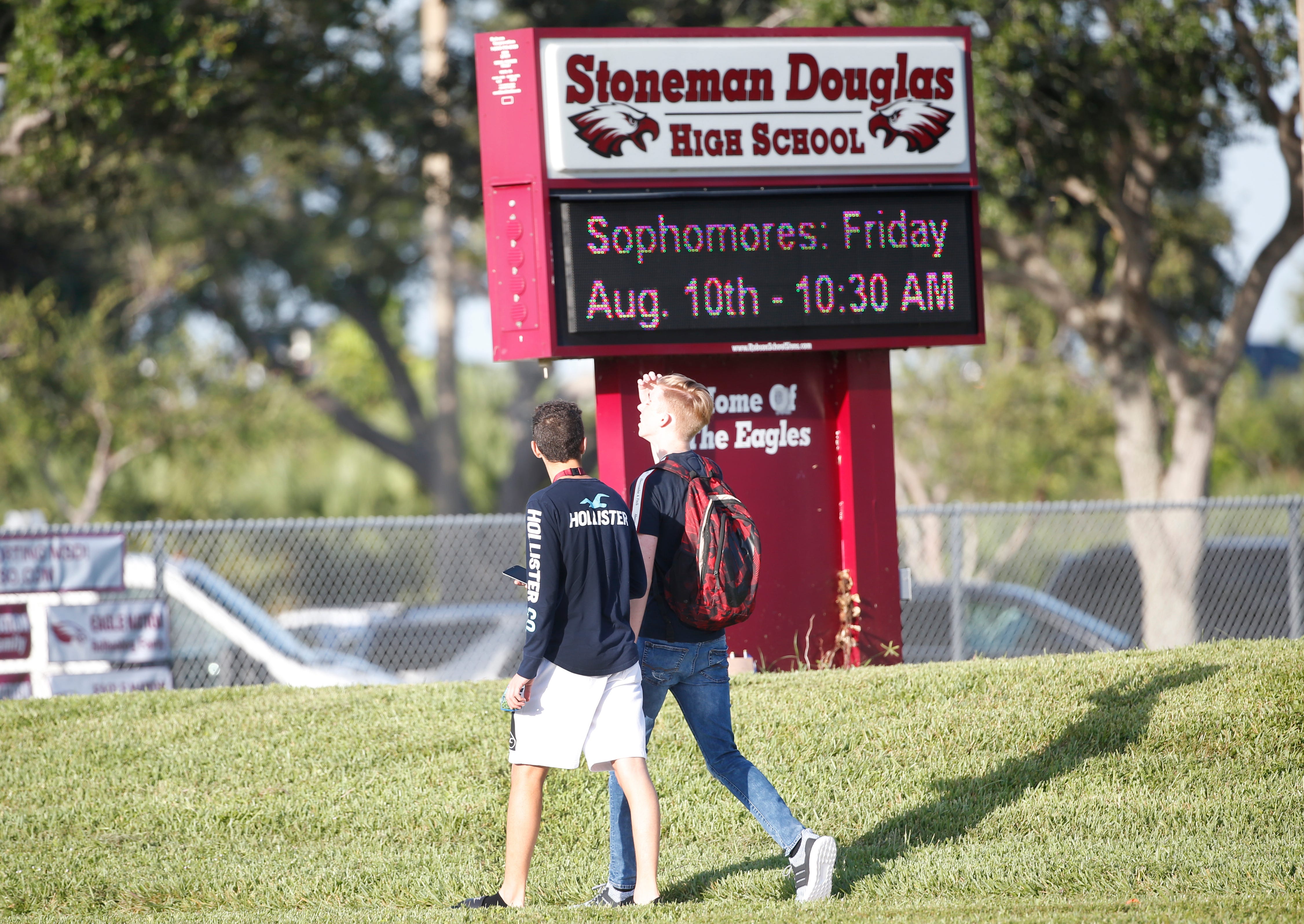Student walk to class at Marjory Stoneman Douglas High School, Aug. 15, 2018, in Parkland, Fla. Students at the school returned to a more secure campus as they began their first new school year since a gunman killed 17 people in the freshman building