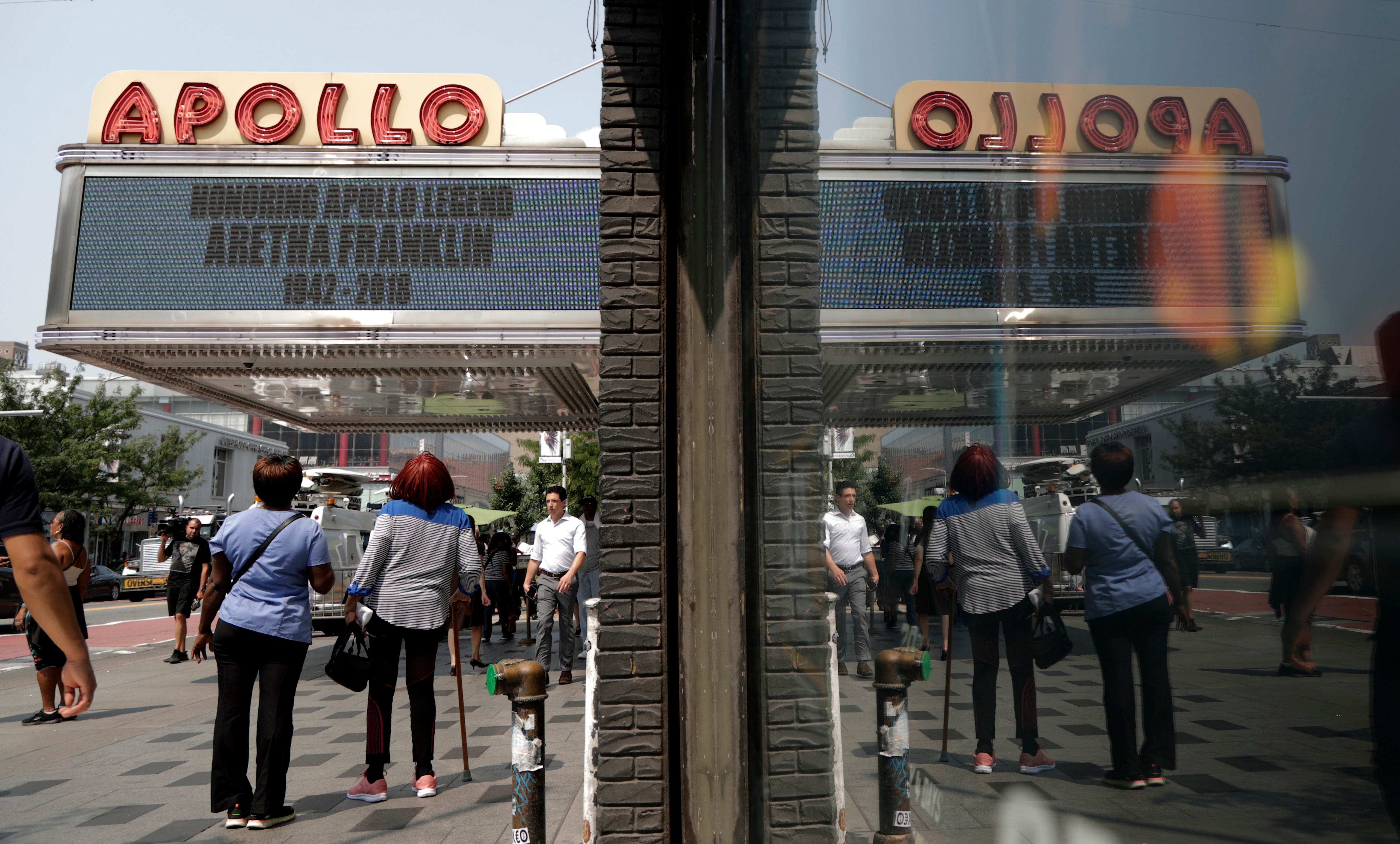 Women look up at the marquee of the Apollo Theater in the Harlem section of New York City, which displays a message honoring singer Aretha Franklin, Aug. 16, 2018. Franklin died in her home in Detroit at age 76 from pancreatic cancer.