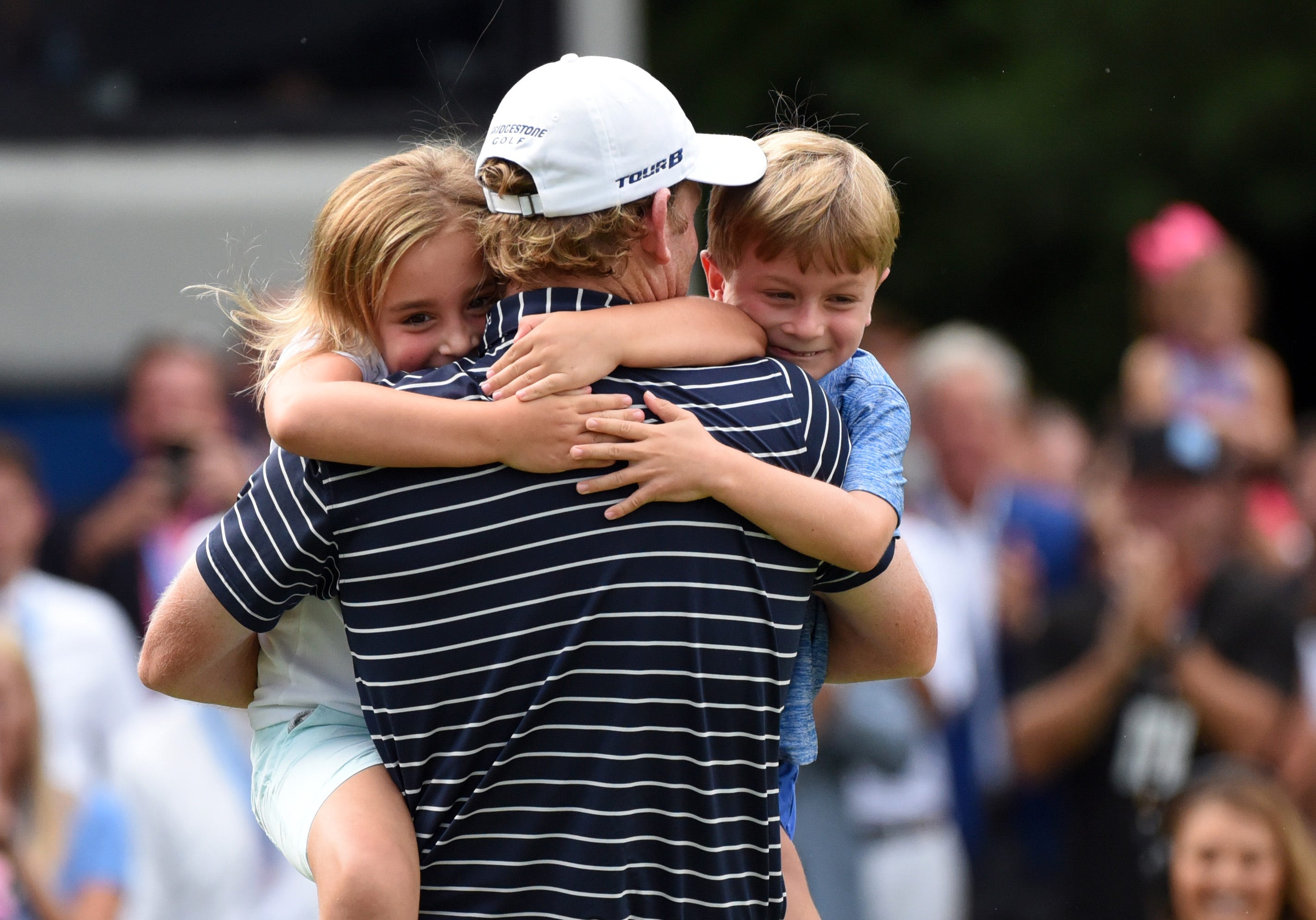 Brandt Snedeker is hugged by his children Lily, left, and Austin, right, after winning the Wyndham Championship golf tournament in Greensboro, N.C., Aug. 19, 2018.