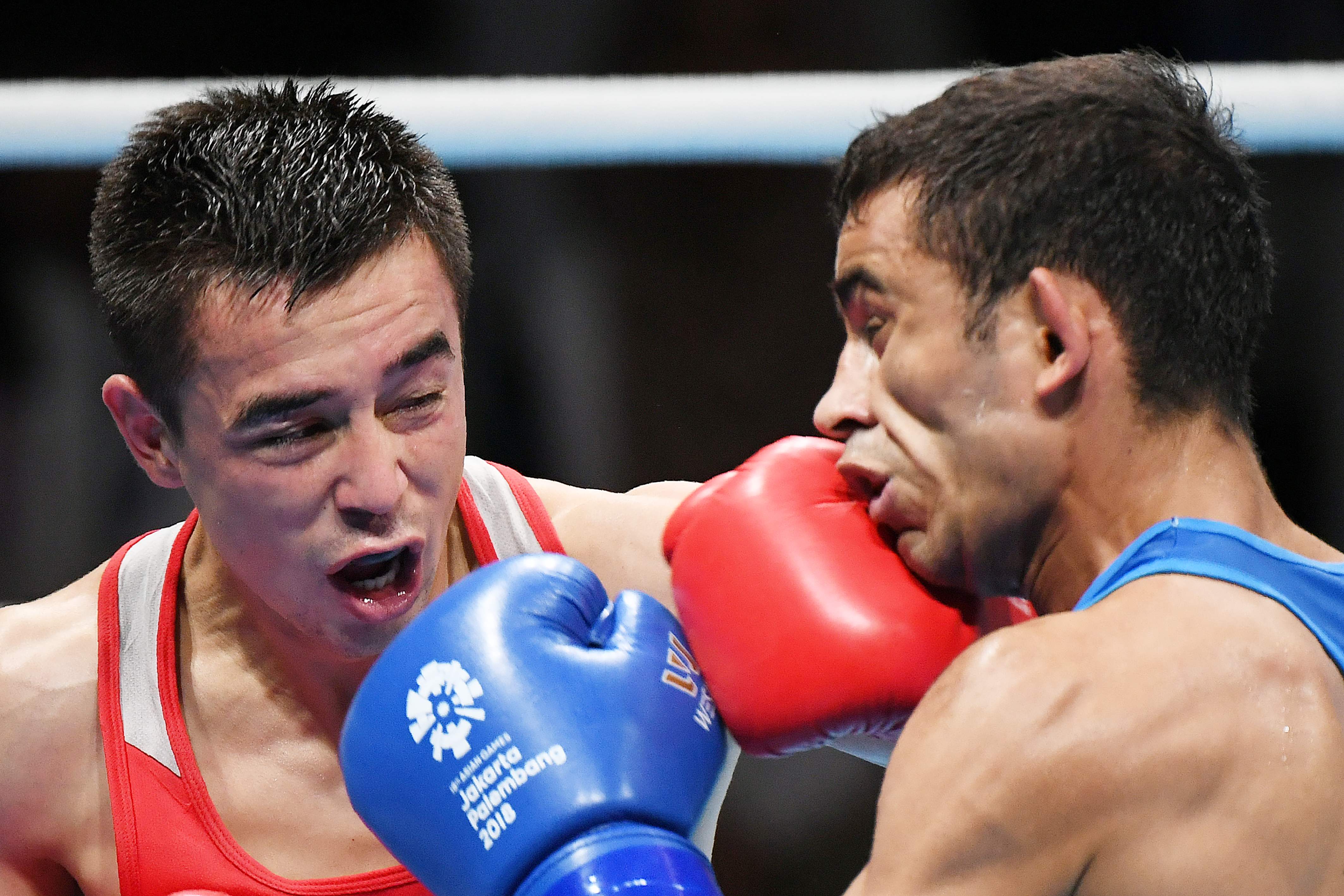 Uzbekistan's Hasanboy Dusmatov, left,fights against India's Amit in their men's light fly (49kg) boxing final at the 2018 Asian Games in Jakarta.