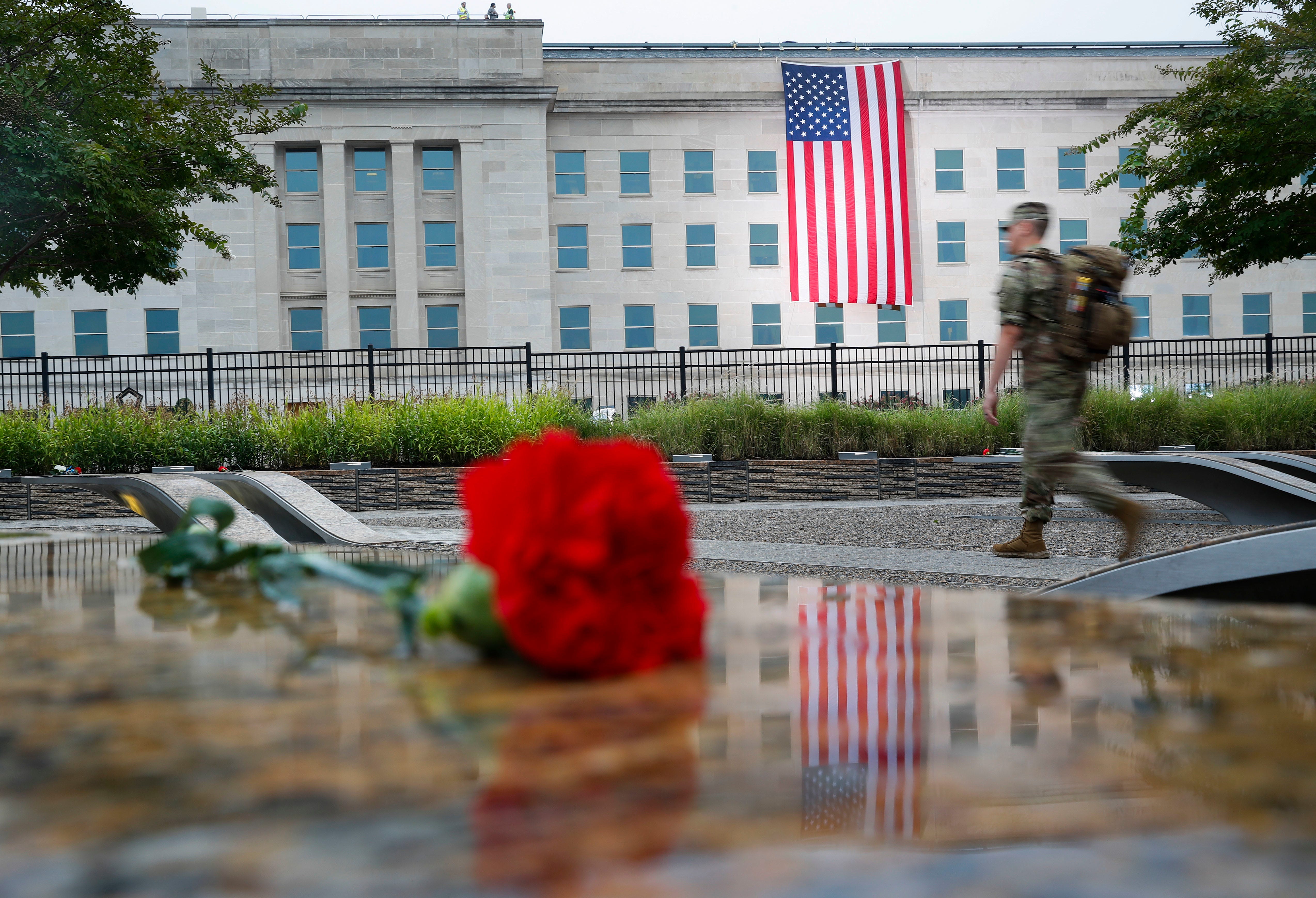 A member of the military walks the grounds of the National 9/11 Pentagon Memorial before the start of the September 11th Pentagon Memorial Observance at the Pentagon on the 17th anniversary of the September 11th attacks, Sept. 11, 2018.