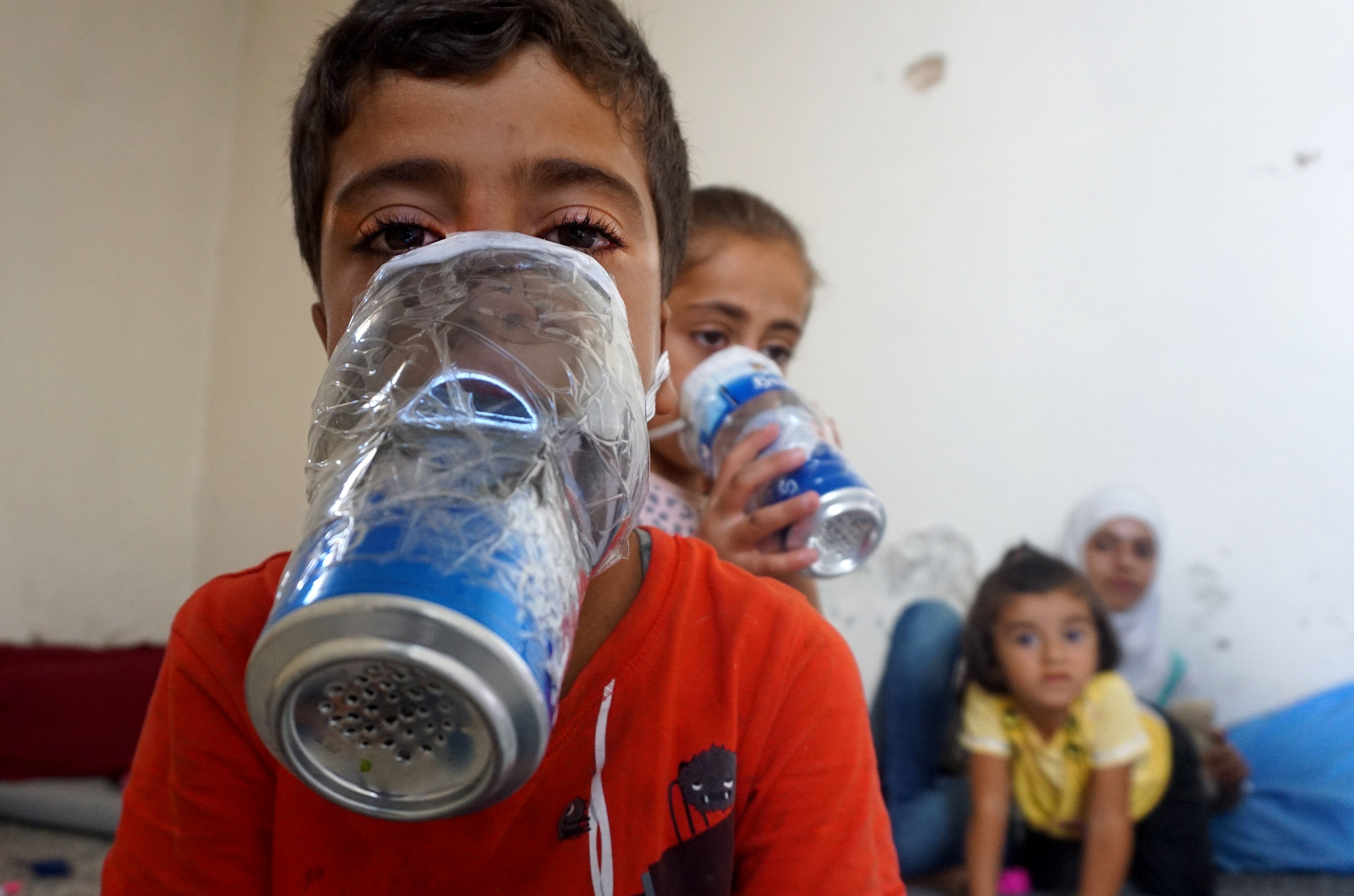 Children try improvised gas masks in their home in Binnish in Syria's rebel-held northern Idlib province as part of preparations for any upcoming raids on Sept. 12, 2018. The Syrian regime and its Russian ally are threatening an offensive to retake t
