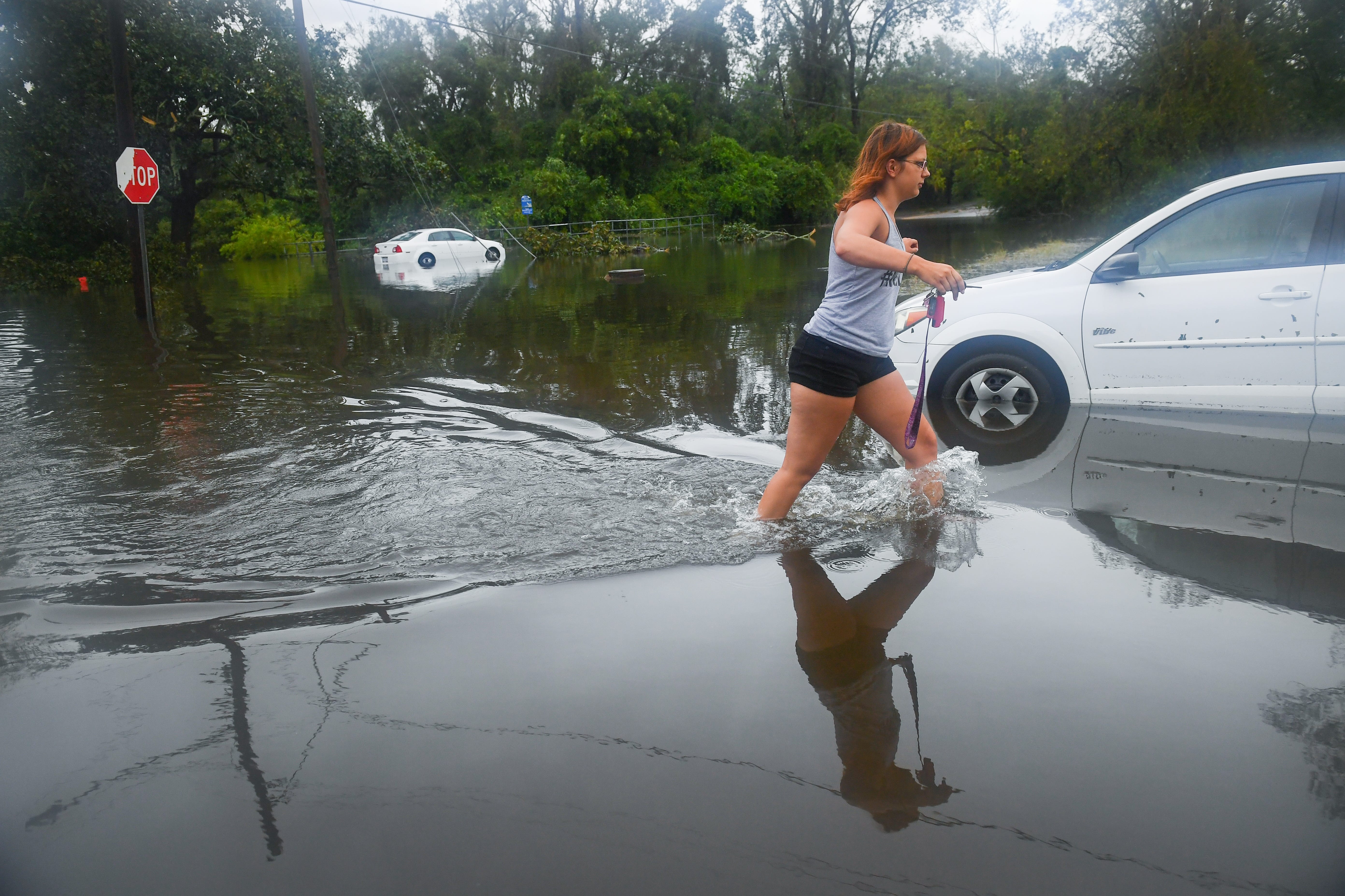 Mackenna Munson, 21, attempts to get to her flooded car on Rankin Street in Wilmington, N.C, on Sunday, Sept. 16, 2018. Her family stayed through Hurricane Florence and weathered the storm minus electric service but woke up on Sunday morning to find 