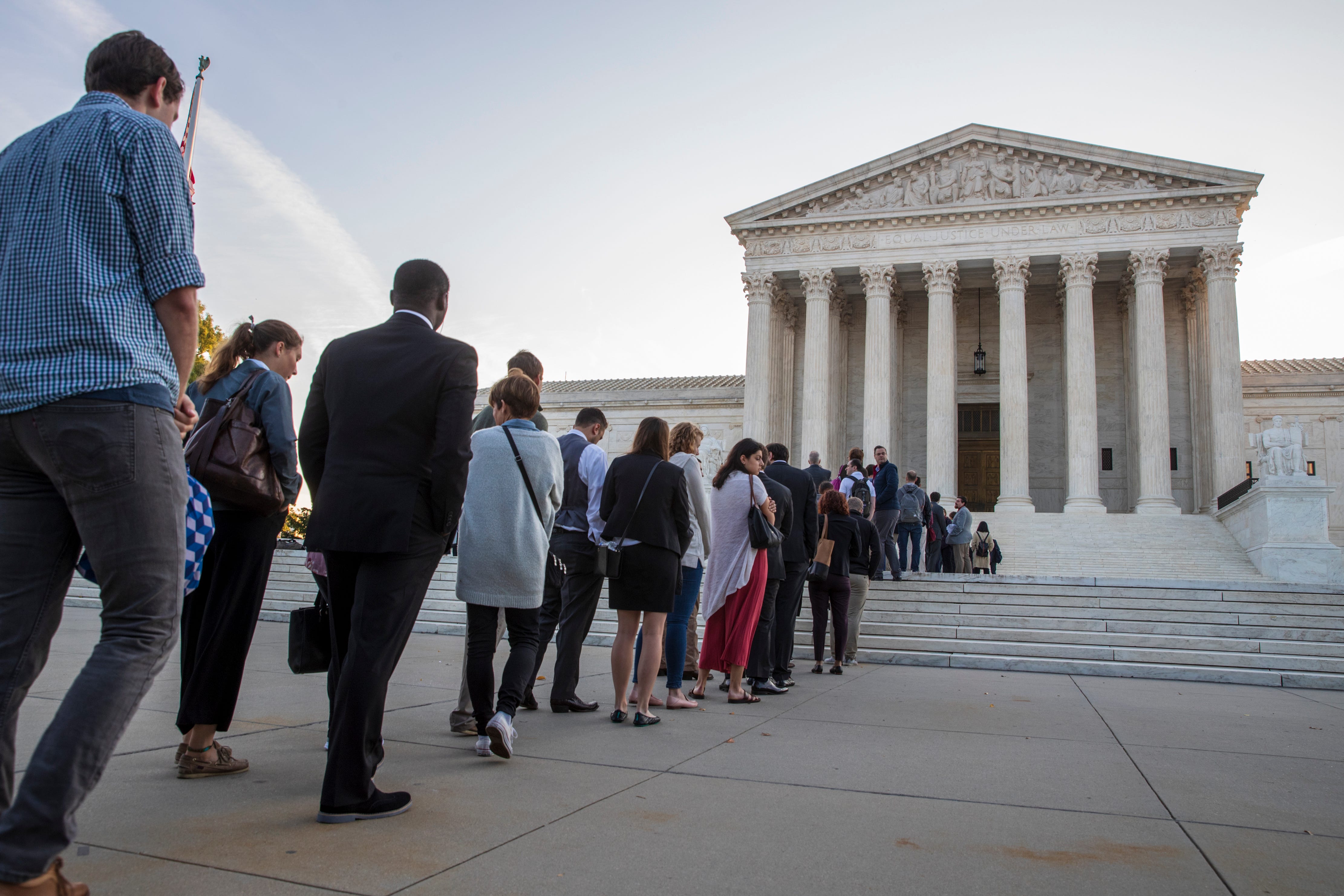 People line up at the Supreme Court on the first day of the new term, on Capitol Hill in Washington, Oct. 1, 2018. Amid the political chaos of Judge Brett Kavanaugh's nomination, the high court's work begins with only eight justices on the bench, fou