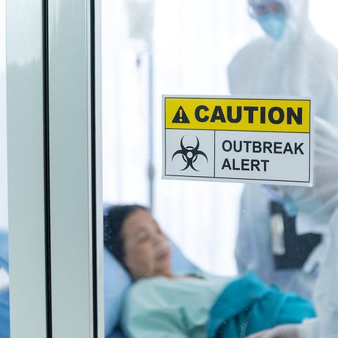 Patient and doctor behind a sign reading "caution,