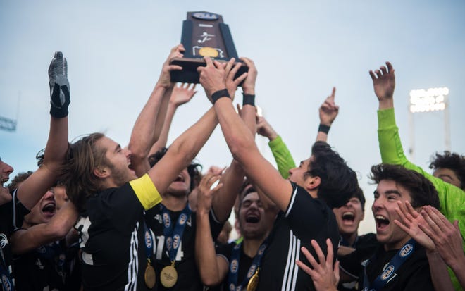 What a difference a year makes. Quaker Valley boys soccer, shown celebrating with its state championship trophy after it won the PIAA Class 2A boys soccer title Nov. 15, 2019, are not able to participate in the upcoming WPIAL tournament due to an outbreak of COVID-19 in the school district. The Quakers girls soccer team also must sit out of the tournament. [Andrew Chiappazzi/BCT file]