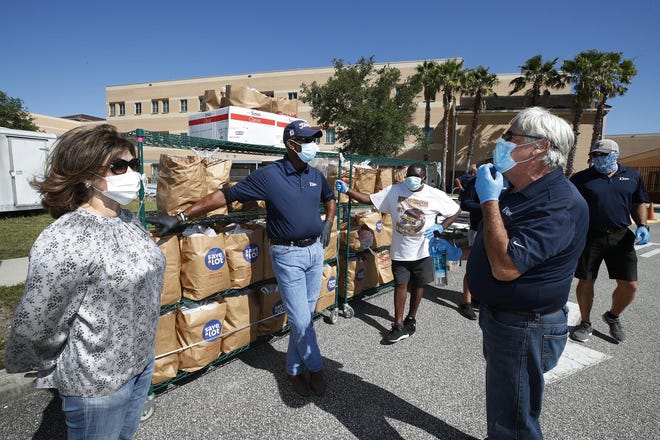 Forough Hosseini with volunteers with Food Brings Hope, ICI, Embry Riddle and Sodexo hand out grocery bags full of food during a food giveaway at Mainland High School in Daytona Beach, Thursday, May 7, 2020.