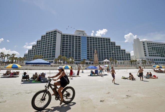 Beachgoers enjoy a sunny afternoon on Friday in front of the Hilton Daytona Beach Oceanfront Resort in Daytona Beach. The approach of Hurricane Isaias, however, is resulting in cancellations for many Volusia County hoteliers this weekend. It's the latest challenge in a summer that has been hurt by the economic effects of the coronavirus pandemic.