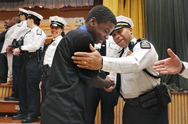 Columbus police Officer Elrico Alli congratulates Jerren Robertson, 13, for graduating from the TAPS (Teen and Police Services) program at Sherwood Middle School on November 21, 2019. Through the program, Columbus Division of Police officers visit Columbus City Schools to mentor groups of middle school students, with a goal of improving youth-police relations and encouraging children to make good choices.