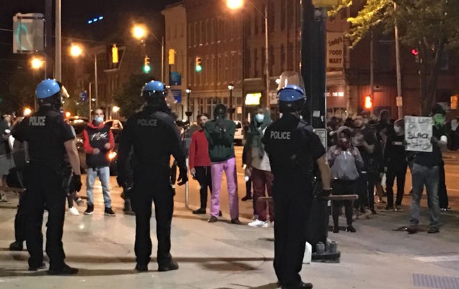 Erie police confront demonstrators at North Park Row and State Street on May 30. The demonstrators vandalized Erie City Hall and hurled bottles and fireworks at police.