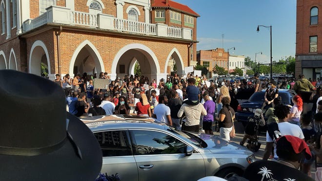 People take part in a protest May 30 at the Market House. Since then, a debate has raged about whether the building with a reputation for being a slave market in the 1800s should be torn down.