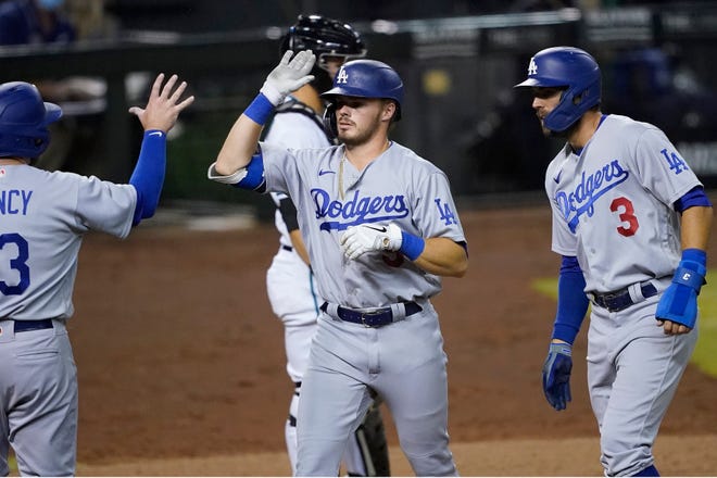 The Dodgers' Gavin Lux celebrates his three-run home run with Max Muncy and Chris Taylor (3) during the 10th inning of a game against the Arizona Diamondbacks on Sept. 8, 2020.