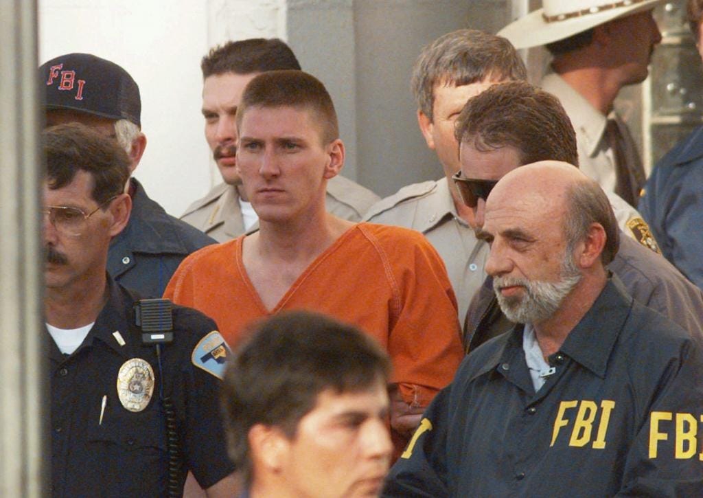 Oklahoma City bomber Timothy McVeigh is escorted by law enforcement officials from the Noble County Courthouse in Perry, Okla., on April 21, 1995. The bombing of the Alfred P. Murray Federal Building on April 19 claimed the lives of 168 people. McVeigh was tried, found guilty and received the death penalty from a jury in Denver on June 13, 1997.