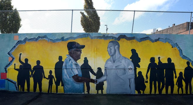A mural that honors Luther Manus Jr., 92, a retired Erie teacher and counselor, is shown Friday at Manus Sunoco at 26 E. 12th St. The mural, created by artists Ceasar Westbrook and Antonio Howard, was sponsored by Erie Arts & Culture.