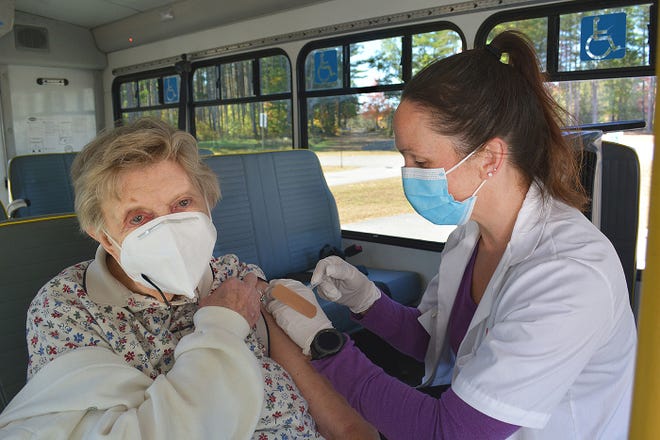 Wilma Liukkonen, 92, a resident of Phoenix Court, Baldwinville, receives a flu shot from Nicole Moore, manager of CVS Pharmacy in Athol, during a recent drive-through flu clinic at the Templeton Senior Community Center in Baldwinville. Liukkonen caught a ride to the senior center on the Templeton COA van. About 30 people, including seniors, town officials and town dispatchers, received their flu shots.