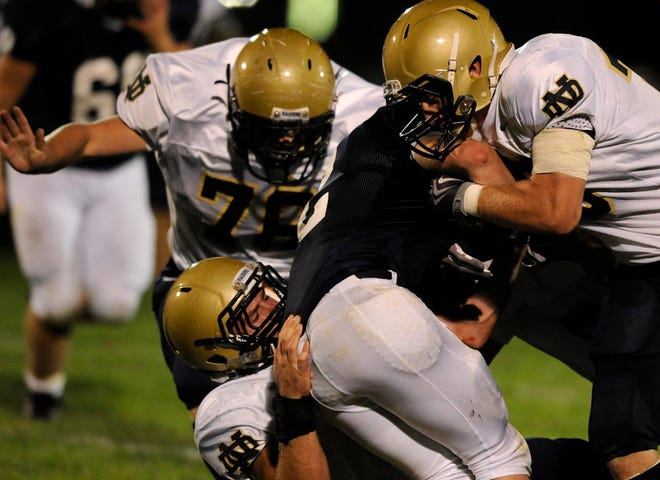 Quincy Notre Dame defenders tackle a member of the Peoria Notre Dame football team during a 2010 game at Peoria Stadium. QND will be joining the Central State Eight for football only starting in 2024.