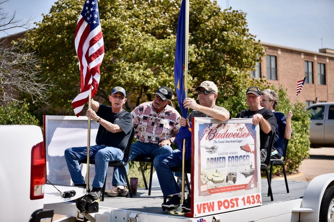 In this file photo, Chuck DeLaney (left) holds the American flag while other veterans ride on the VFW Post 1432 float in a Brookville Labor Day Parade.