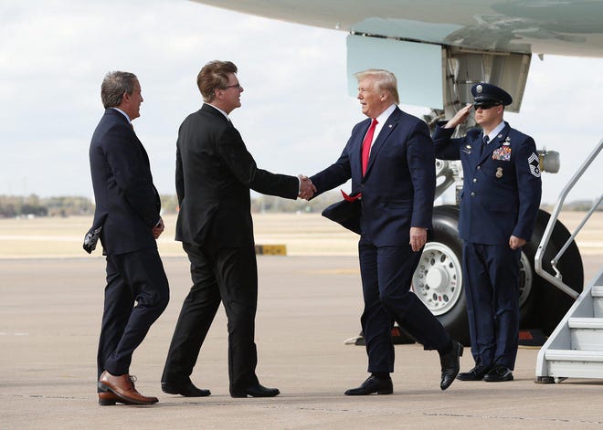 Texas Lt. Gov. Dan Patrick, center, and Attorney General Ken Paxton greet President Donald Trump at Austin-Bergstrom International Airport during Trump's visit to Austin in November 2019.