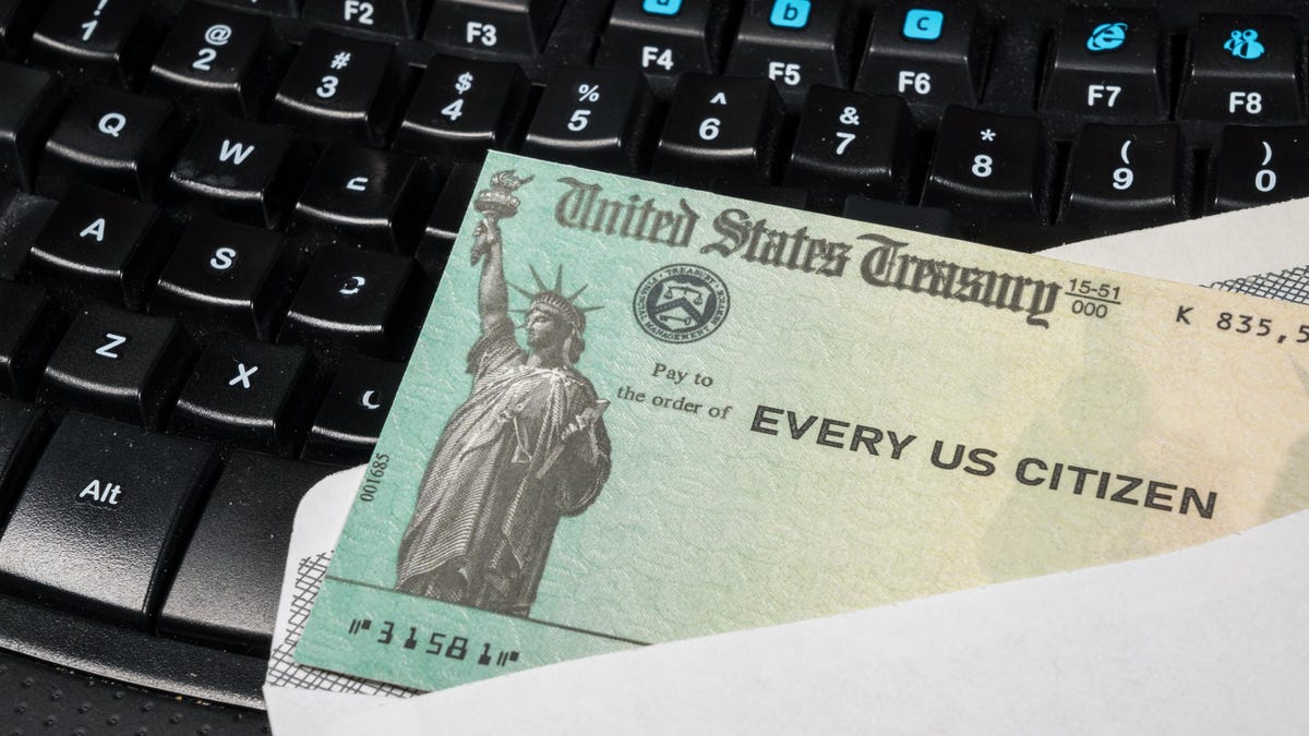 Federal government-issued check lying on a computer keyboard.