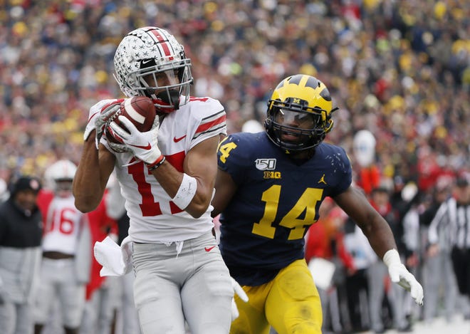 Ohio State wide receiver Chris Olave, here catching a touchdown pass behind Michigan's Josh Metellus in 2019, said one reason he returned to OSU this season was for one more game against the Wolverines.