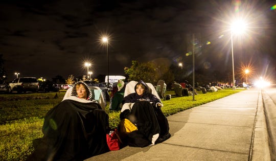 Terri Kado, 66, right, and Patty Tubbs, 68, friends from Fort Myers Beach, Fla., wait in line for a COVID-19 vaccine in the early morning hours of Dec. 30 at Lakes Park Regional Library. They got in line at midnight. The two enjoyed the experience, watching the moon move through the sky. To them, the vaccine brings peace of mind and a positive start to the new year.